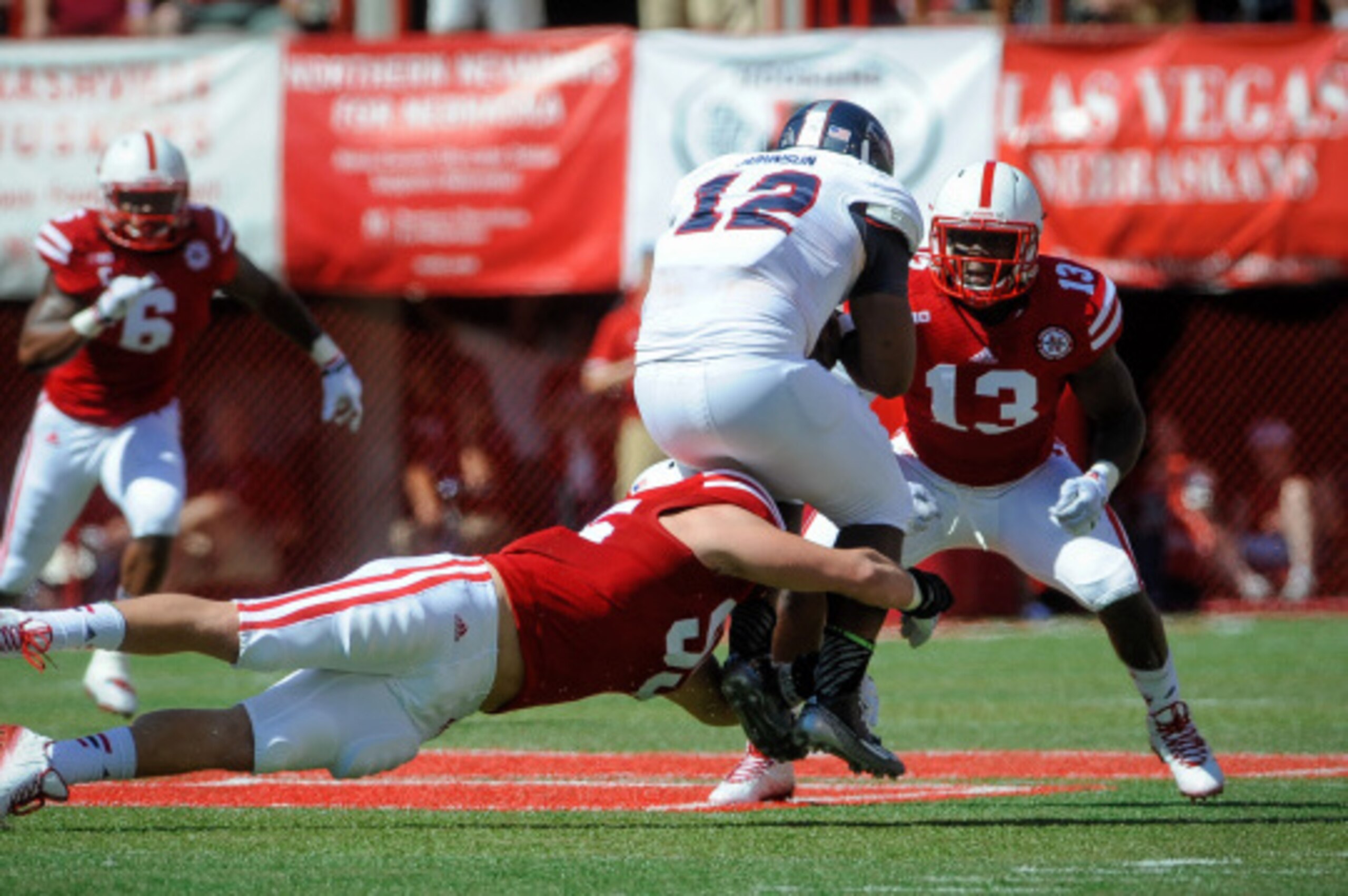 LINCOLN, NE - AUGUST 30: defensive end Jack Gangwish #95 of the Nebraska Cornhuskers wraps up quarterback Jaquez Johnson #12 of the Florida Atlantic Owls while linebacker Zaire Anderson #13 of the Nebraska Cornhuskers waits during their game at Memorial S