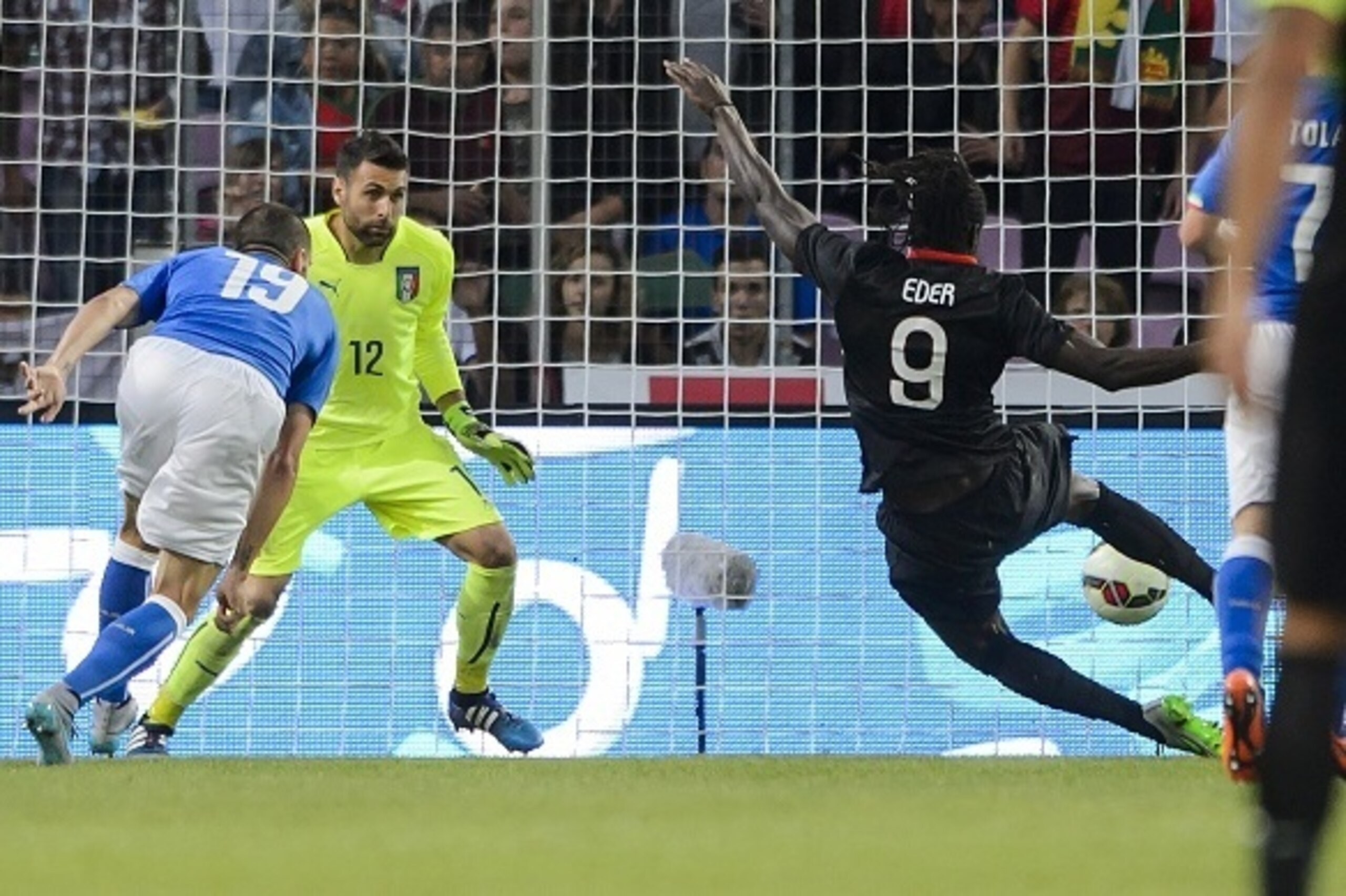 Portugal's forward Eder (R) scores the team's first goal against Italy's goalkeeper Salvatore Sirigu (C) and Italy's defender Leonardo Bonucci during the friendly game Portugal against Italy on the Stade de Geneve on June 16, 2015 in Geneva.  AFP PHOTO / 