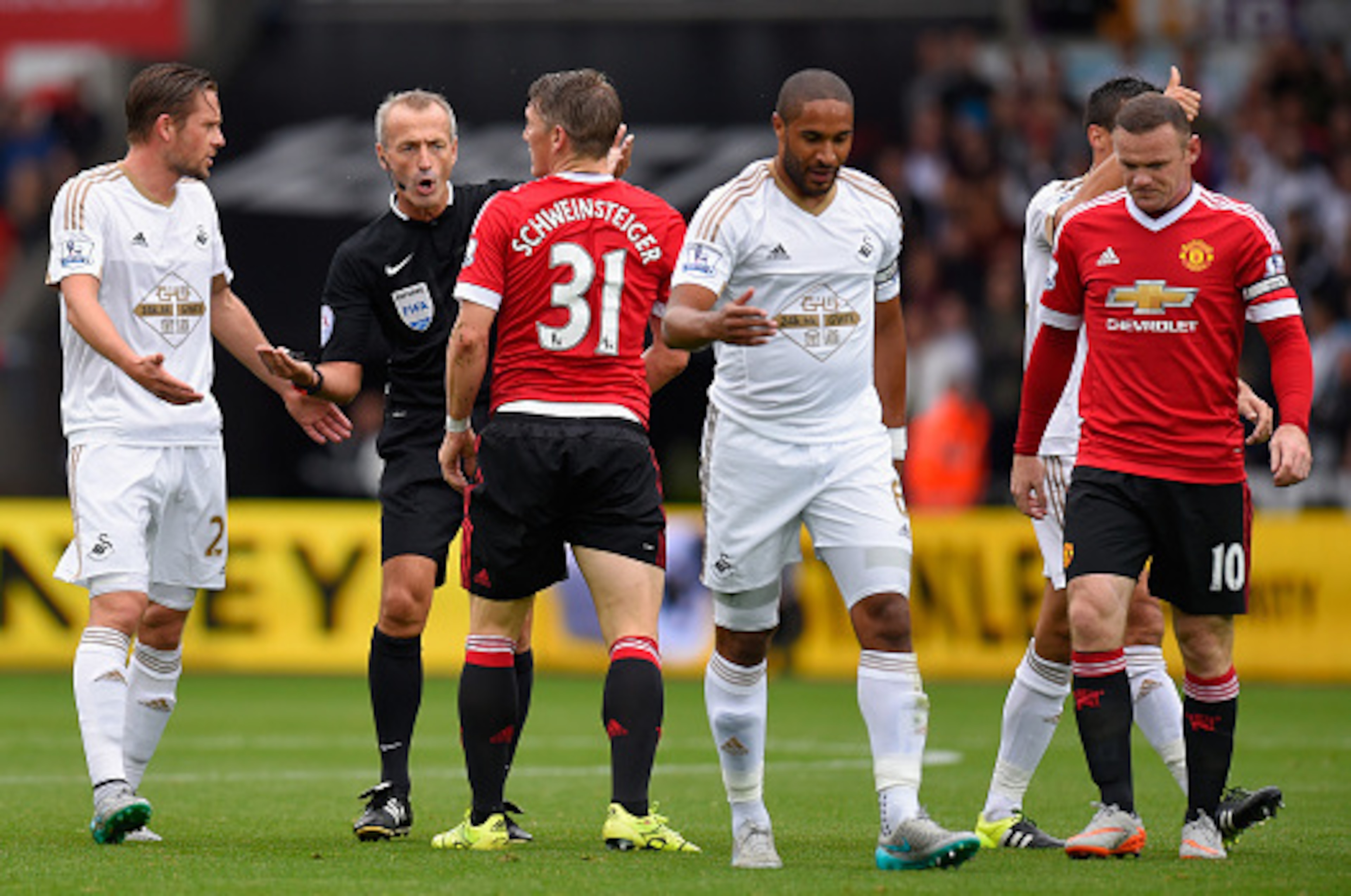 SWANSEA, WALES - AUGUST 30:  Manchester United player Bastian Schweinsteiger is spoken to by referee Martin Atkinson during the Barclays Premier League match between Swansea City and Manchester United on August 30, 2015 in Swansea, United Kingdom.  (Photo