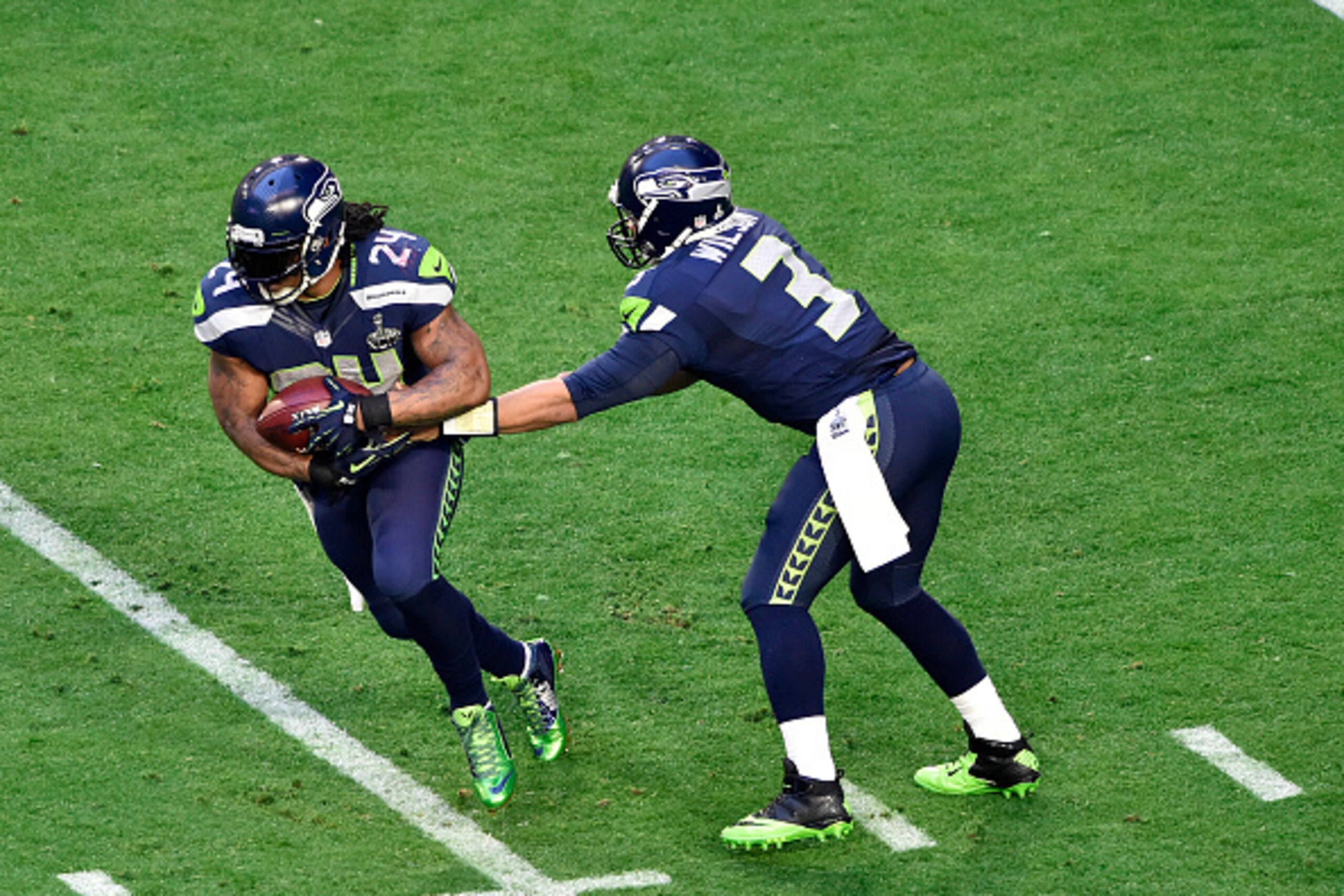 GLENDALE, AZ - FEBRUARY 01 :  Marshawn Lynch #24 of the Seattle Seahawks takes the handoff from Russell Wilson #3 against the New England Patriots during Super Bowl XLIX February 1, 2015 at the University of Phoenix Stadium in Glendale, Arizona. The Patri