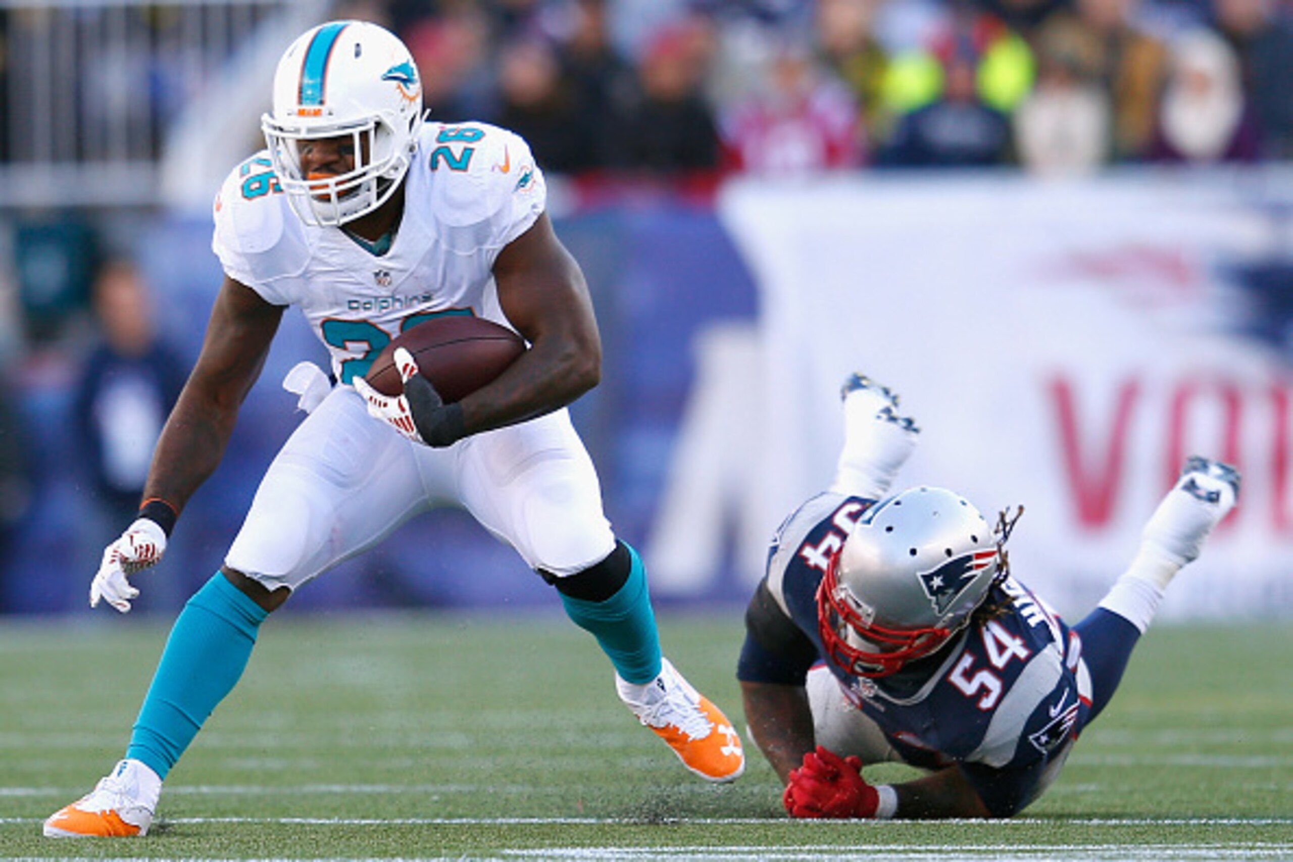 FOXBORO, MA - DECEMBER 14:  Lamar Miller #26 of the Miami Dolphins carries the ball during the first quarter against the New England Patriots at Gillette Stadium on December 14, 2014 in Foxboro, Massachusetts.  (Photo by Jim Rogash/Getty Images)