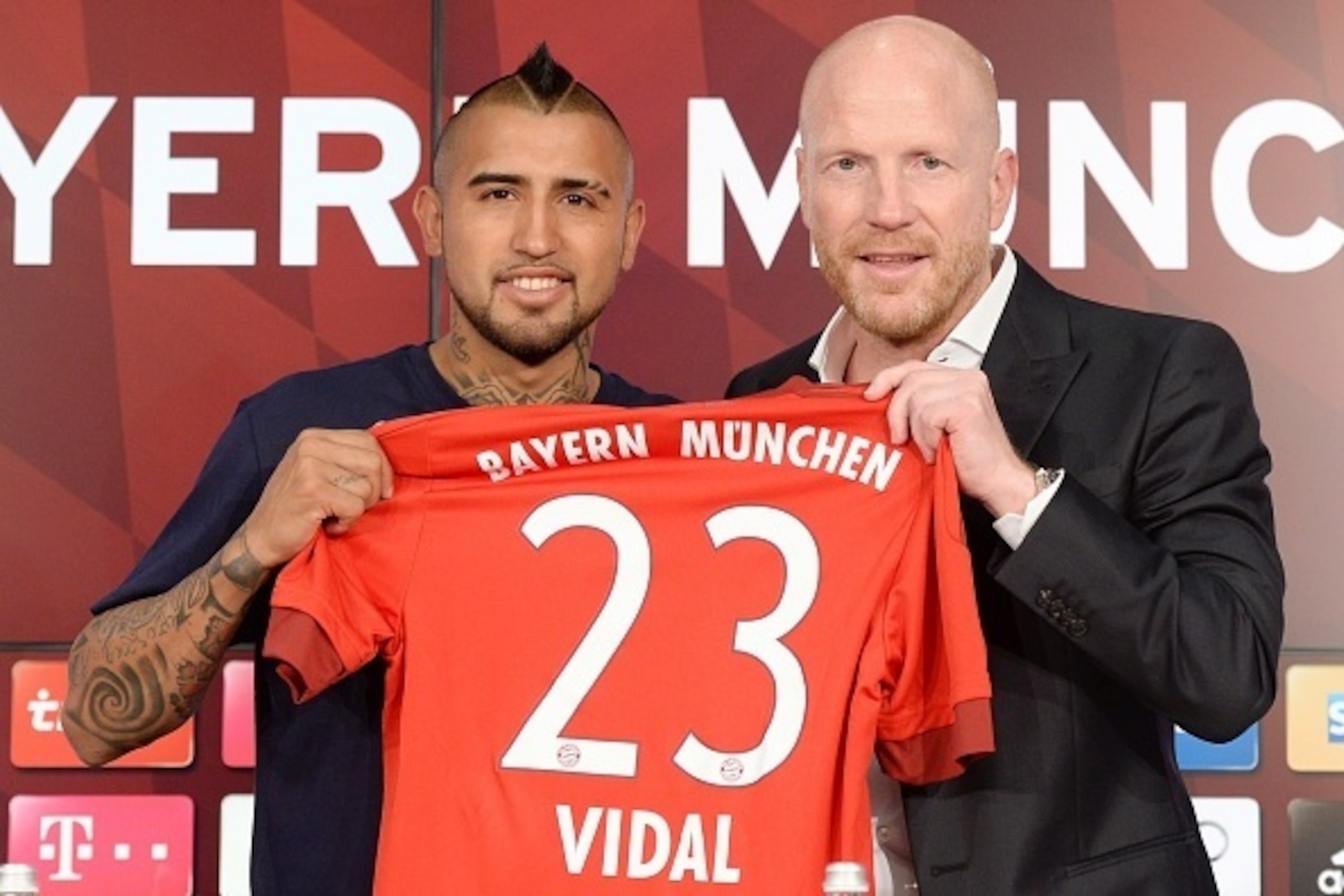 German first division Bundesliga football club Bayern Munich's new recruit Chilean midfielder Arturo Vidal (L) and the club's sporting director Matthias Sammer pose for a picture during a press conference on July 28, 2015, in Munich, southern Germany. AFP