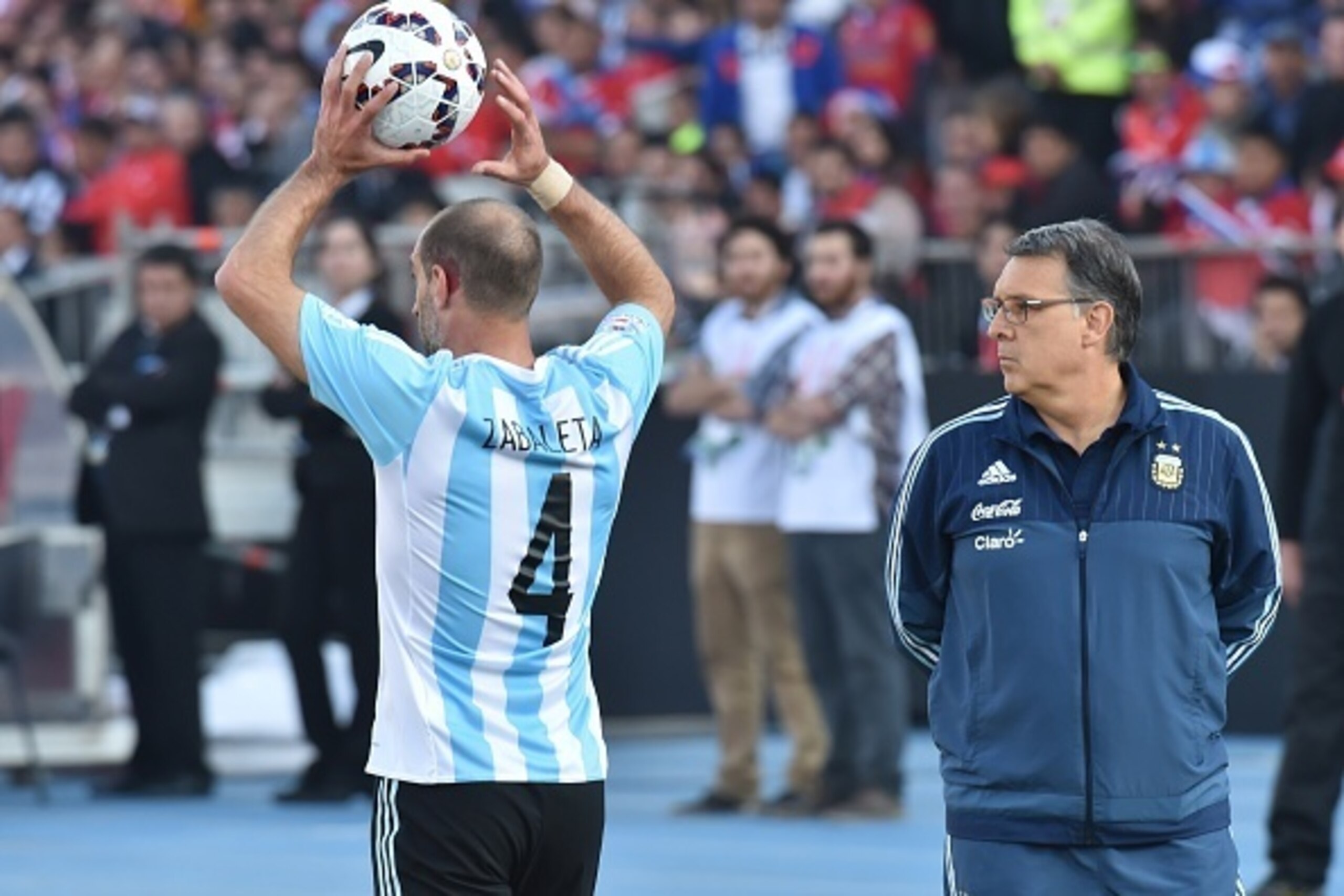 Argentina's defender Pablo Zabaleta (L) throws the ball next tio Argentina's coach Gerardo Martino during their 2015 Copa America final football match against Chile, in Santiago, Chile, on July 4, 2015. AFP PHOTO / NELSON ALMEIDA        (Photo credit shou