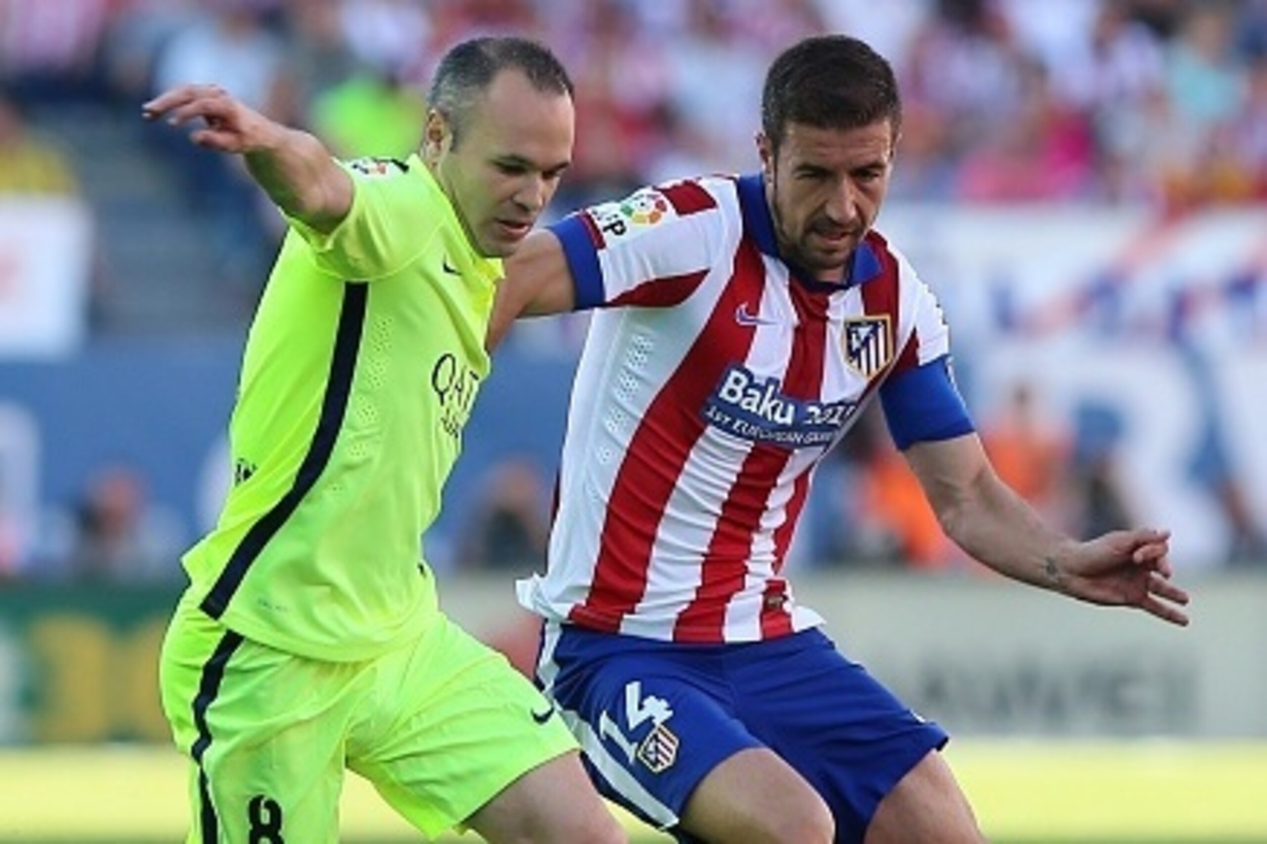 Barcelona's midfielder Andres Iniesta (L) vies with Atletico Madrid's midfielder and captain Gabi during the Spanish league football match Sevilla FC vs UD Almeria at the Ramon Sanchez Pizjuan stadium in Sevilla on May 17, 2015.   AFP PHOTO / CRISTINA QUI