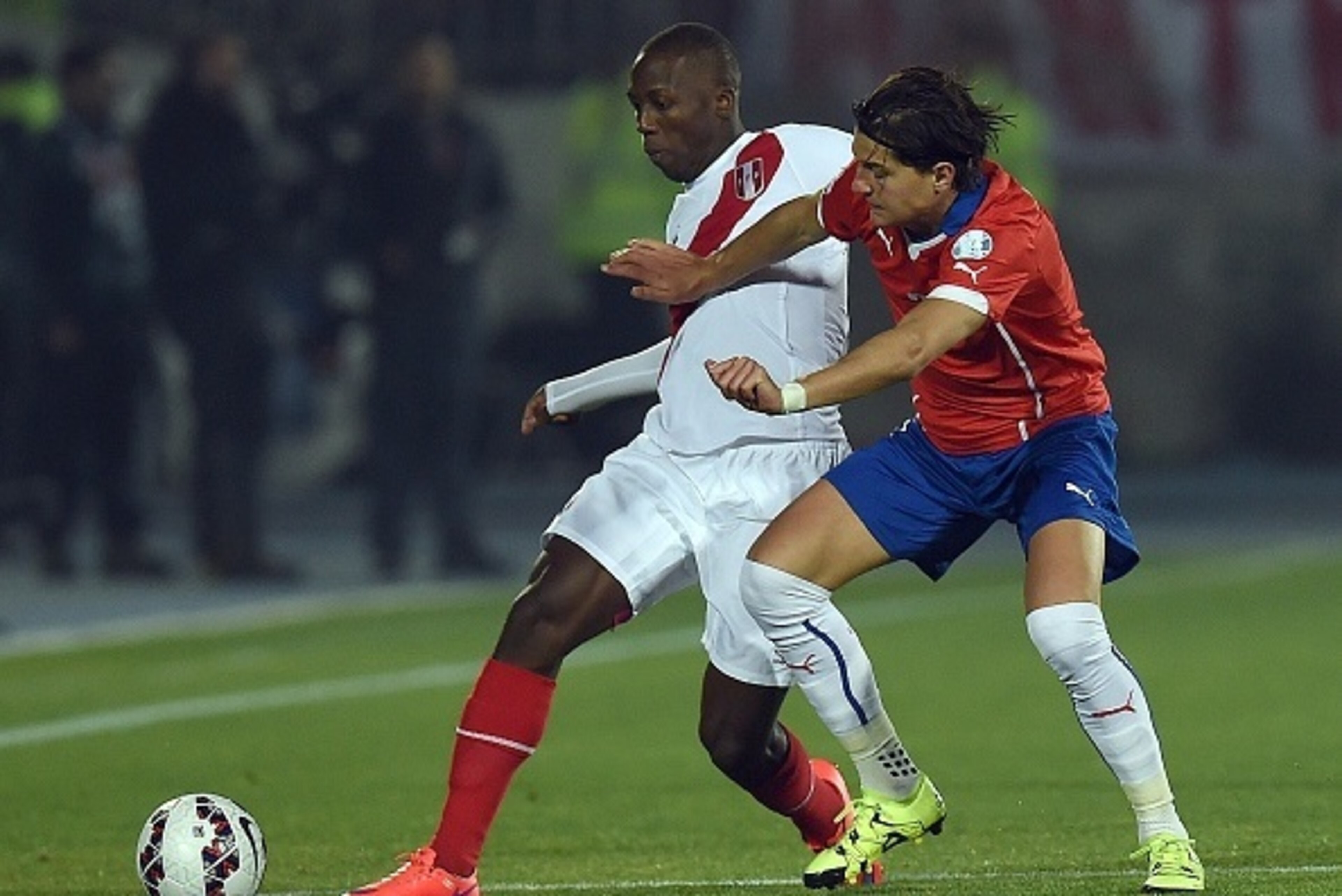 Peru's defender Luis Advincula (L) and Chile's defender Miiko Albornoz vie for the ball during their 2015 Copa America football championship semi-final match, in Santiago, on June 29, 2015.   AFP PHOTO / PABLO PORCIUNCULA        (Photo credit should read 