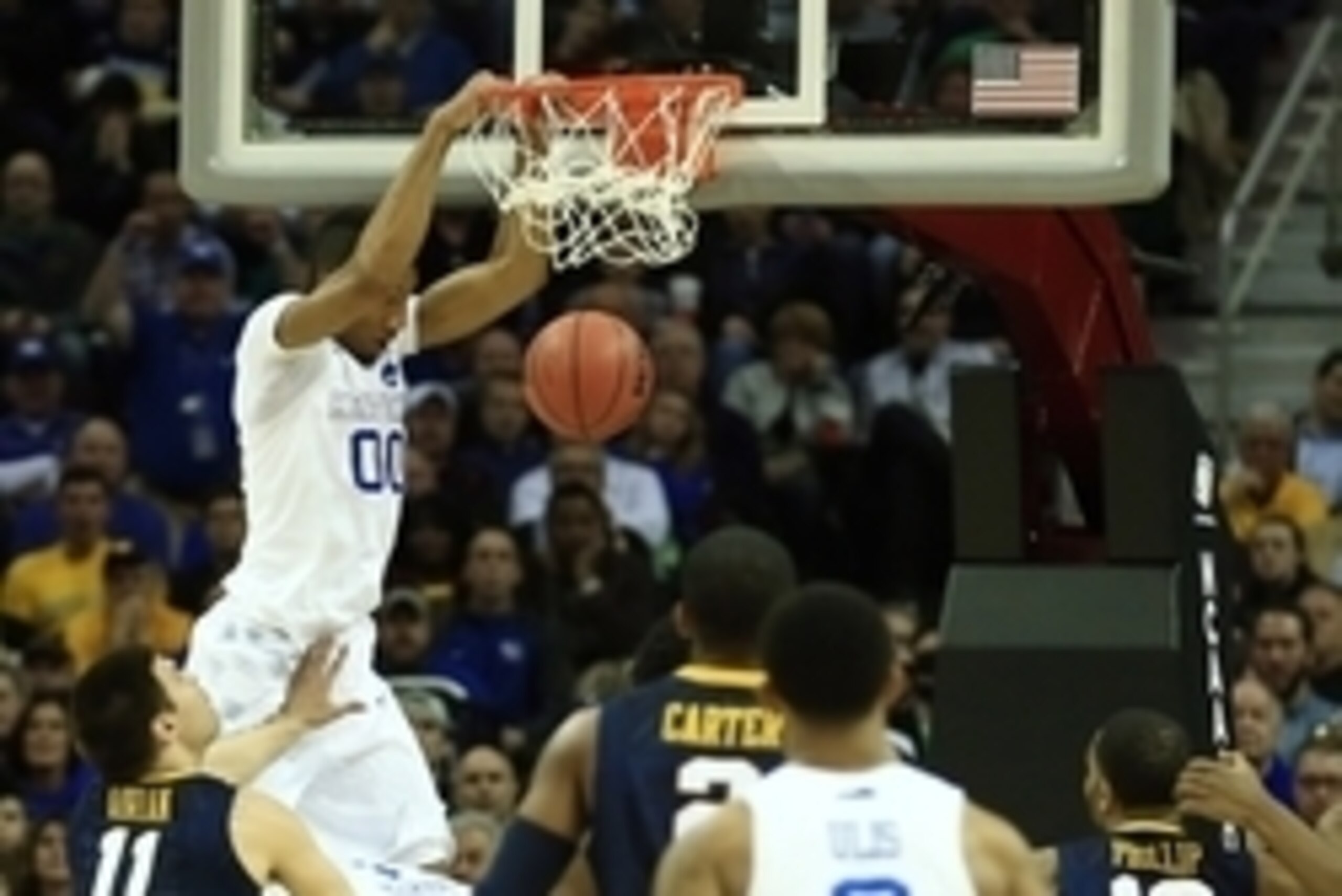 Mar 26, 2015; Cleveland, OH, USA; Kentucky Wildcats forward Marcus Lee (00) dunks while guarded by West Virginia Mountaineers forward Nathan Adrian (11)  during the first half in the semifinals of the midwest regional of the 2015 NCAA Tournament at Quicke