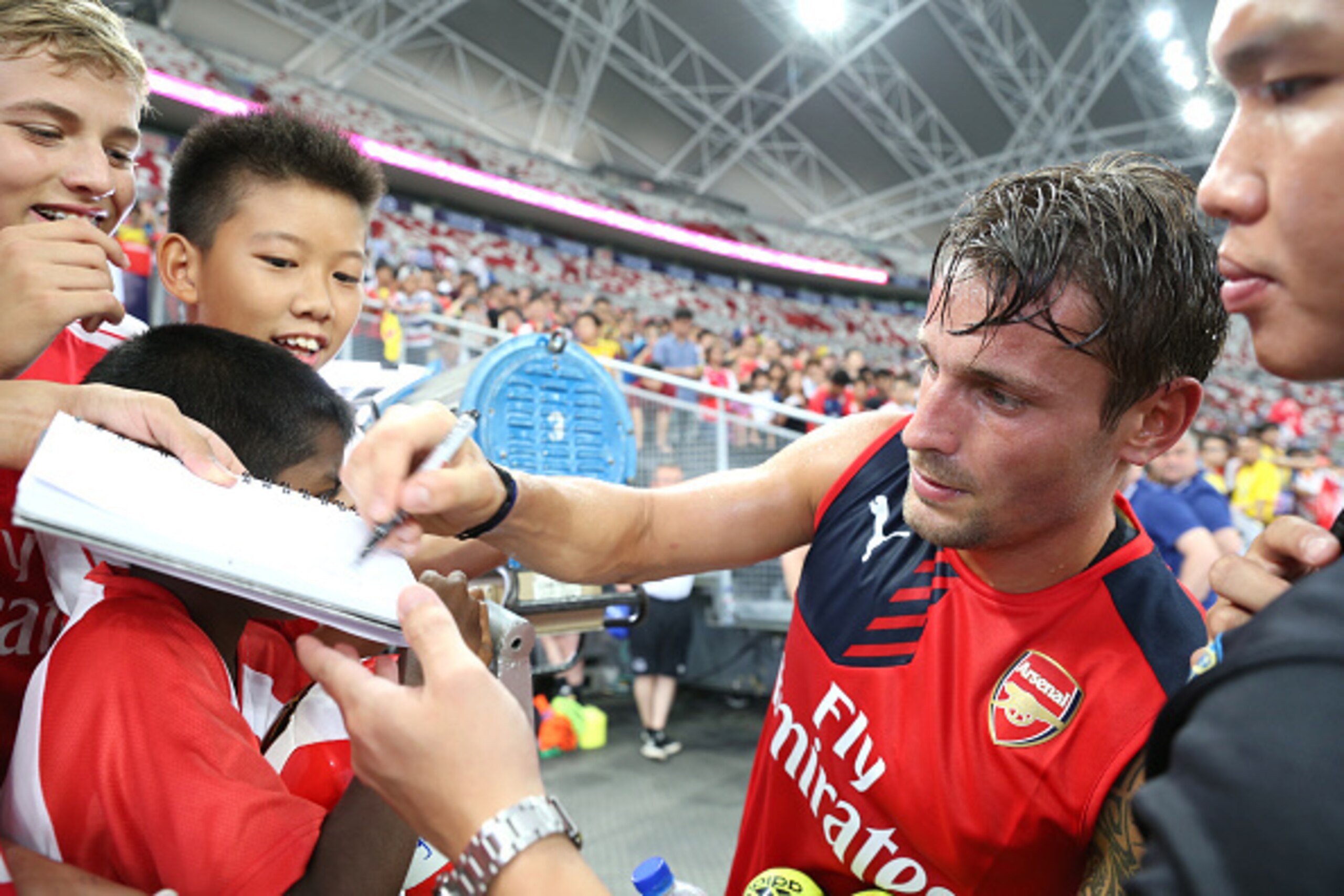 SINGAPORE - JULY 14:  Mathieu Debuchy of Arsenal signs autographs for fans during the Barclays Asia Trophy Training Session at the National Stadium on July 14, 2015 in Singapore.  (Photo by Lionel Ng/Getty Images)