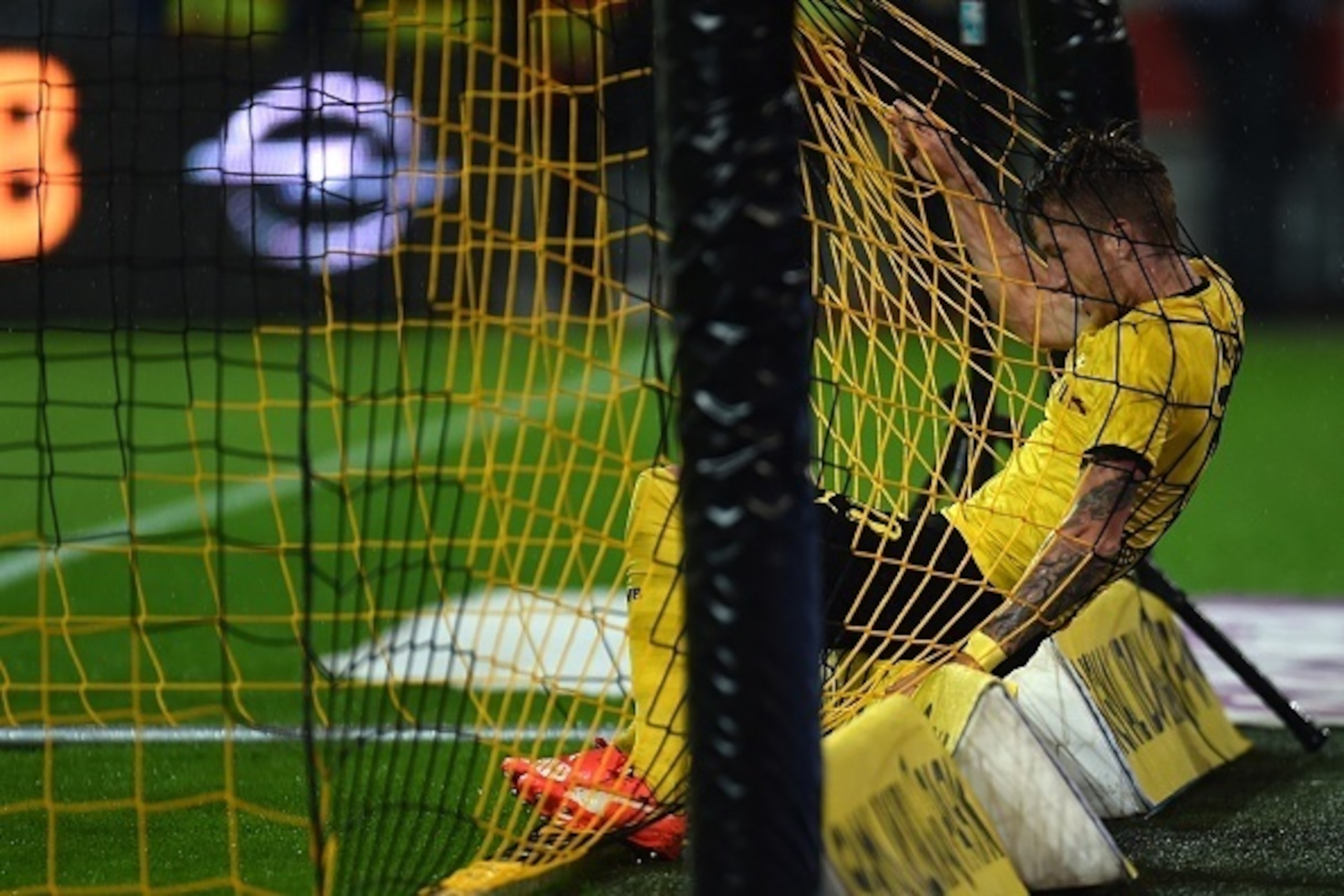 Dortmund's striker Marco Reus struggles in the goal net during the UEFA Europa League second-leg play-off match between Borussia Dortmund and Odds BK in Dortmund on August 28, 2015. Dortmund won the match 7-2. AFP PHOTO / PATRIK STOLLARZ        (Photo cre