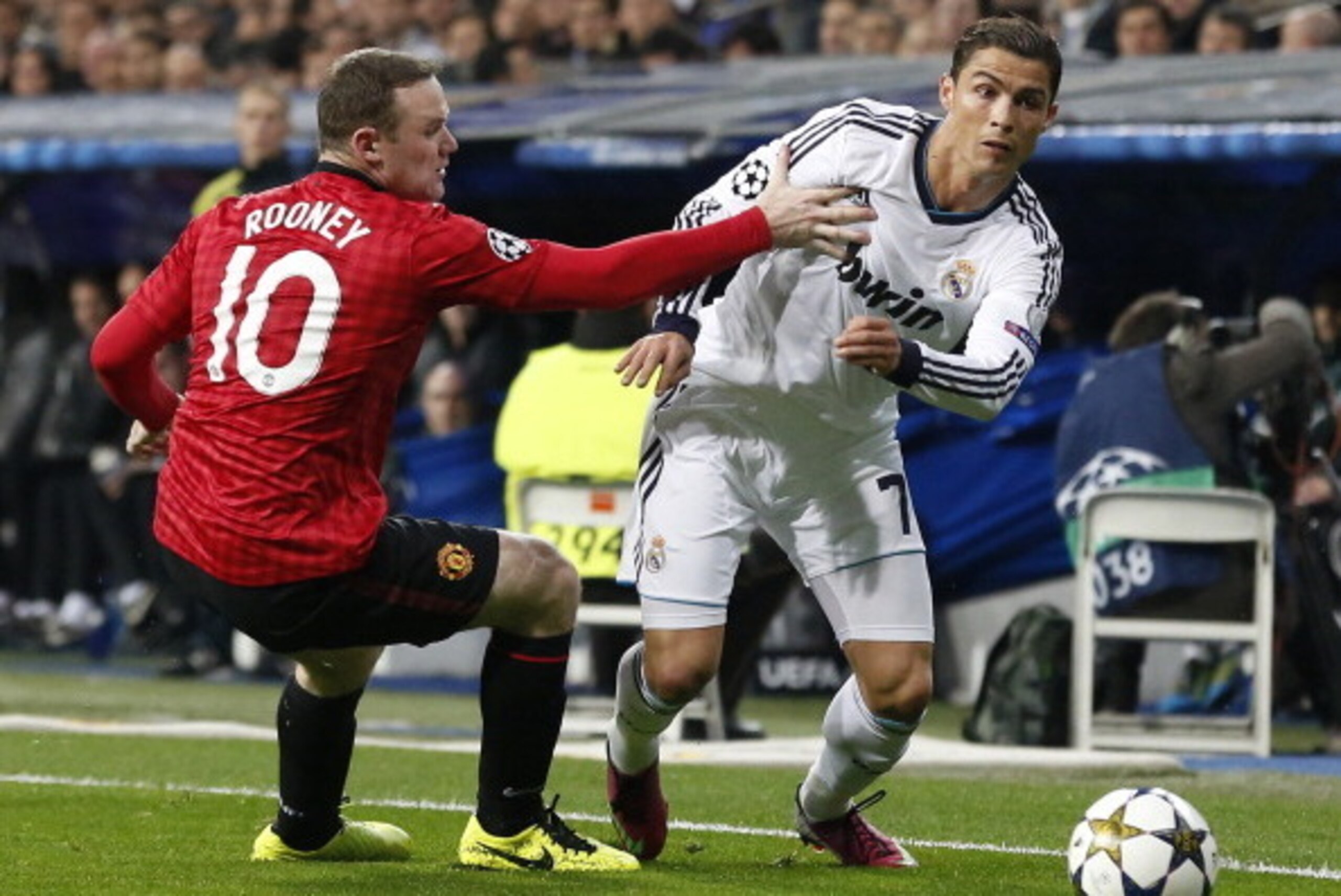 Real Madrid's Portuguese forward Cristiano Ronaldo (R) vies with Manchester United's striker Wayne Rooney during the UEFA Champions League round of 16 first leg football match Real Madrid CF vs Manchester United FC at the Santiago Bernabeu stadium in Madr