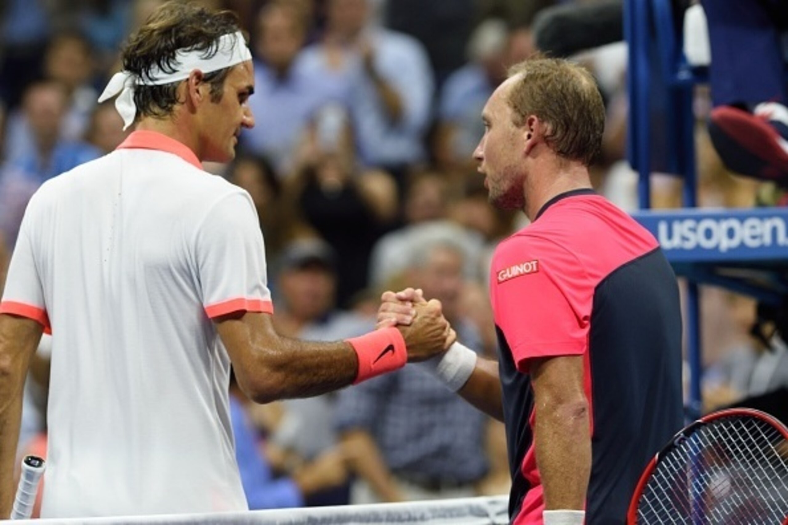 Roger Federer of Switzerland meets Steve Darcis of Belgium at the net after their  2015 US Open men's singles round two match at the USTA Billie Jean King National Tennis Center September 3, 2015 in New York.        AFP PHOTO /  DON EMMERT        (Photo c