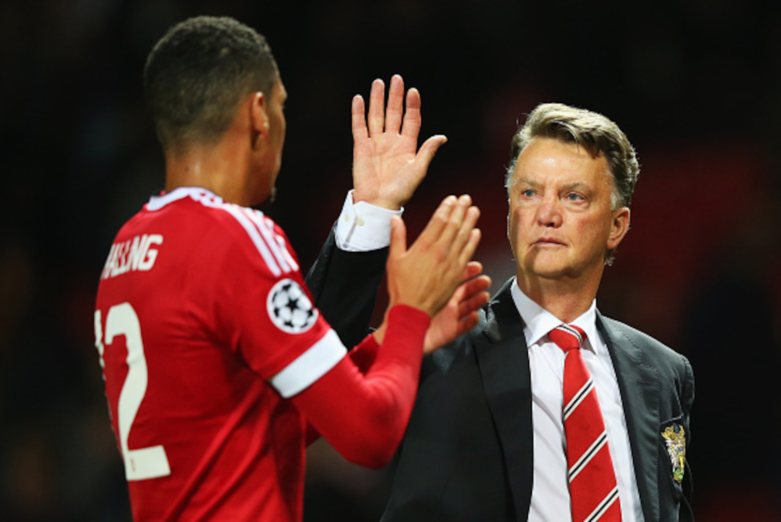 MANCHESTER, ENGLAND - AUGUST 18:  Louis van Gaal, manager of Manchester United celebrates victory with Chris Smalling after the UEFA Champions League Qualifying Round Play Off First Leg match between Manchester United and Club Brugge at Old Trafford on Au