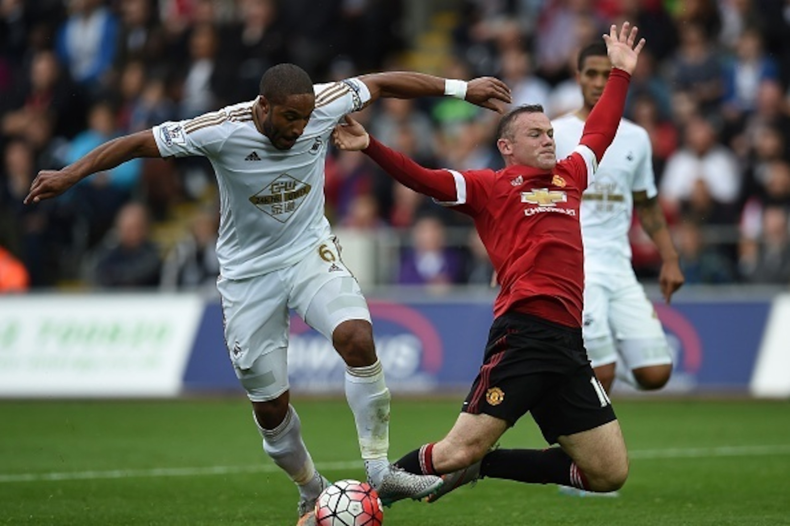 Swansea City's English-born Welsh defender Ashley Williams (L) challenges Manchester United's English striker Wayne Rooney in the penalty area during the English Premier League football match between Swansea City and Manchester United at The Liberty Stadi