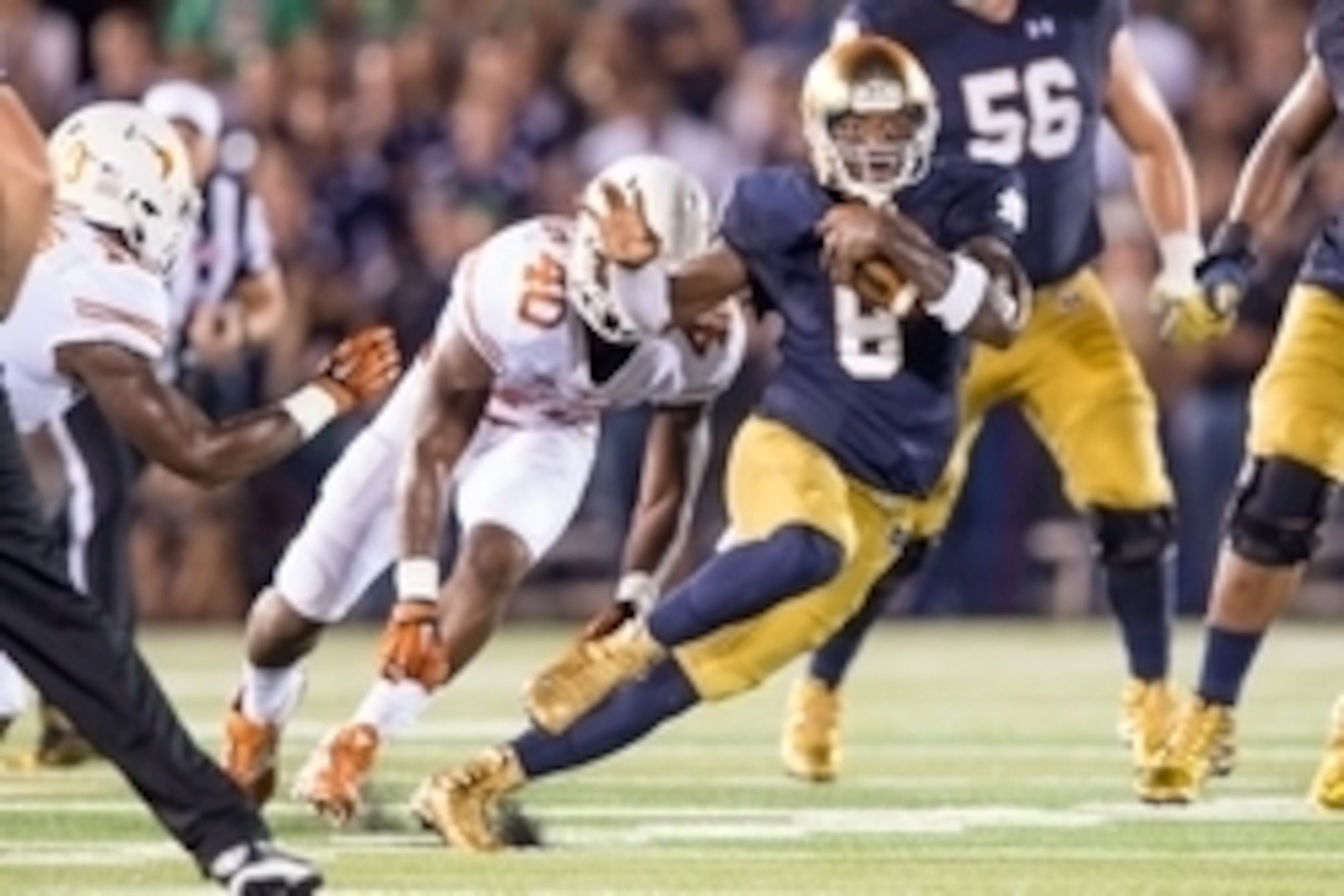 Sep 5, 2015; South Bend, IN, USA; Notre Dame Fighting Irish quarterback Malik Zaire (8) runs the ball as Texas Longhorns defensive end Naashon Hughes (40) pursues in the second quarter at Notre Dame Stadium. Mandatory Credit: Matt Cashore-USA TODAY Sports