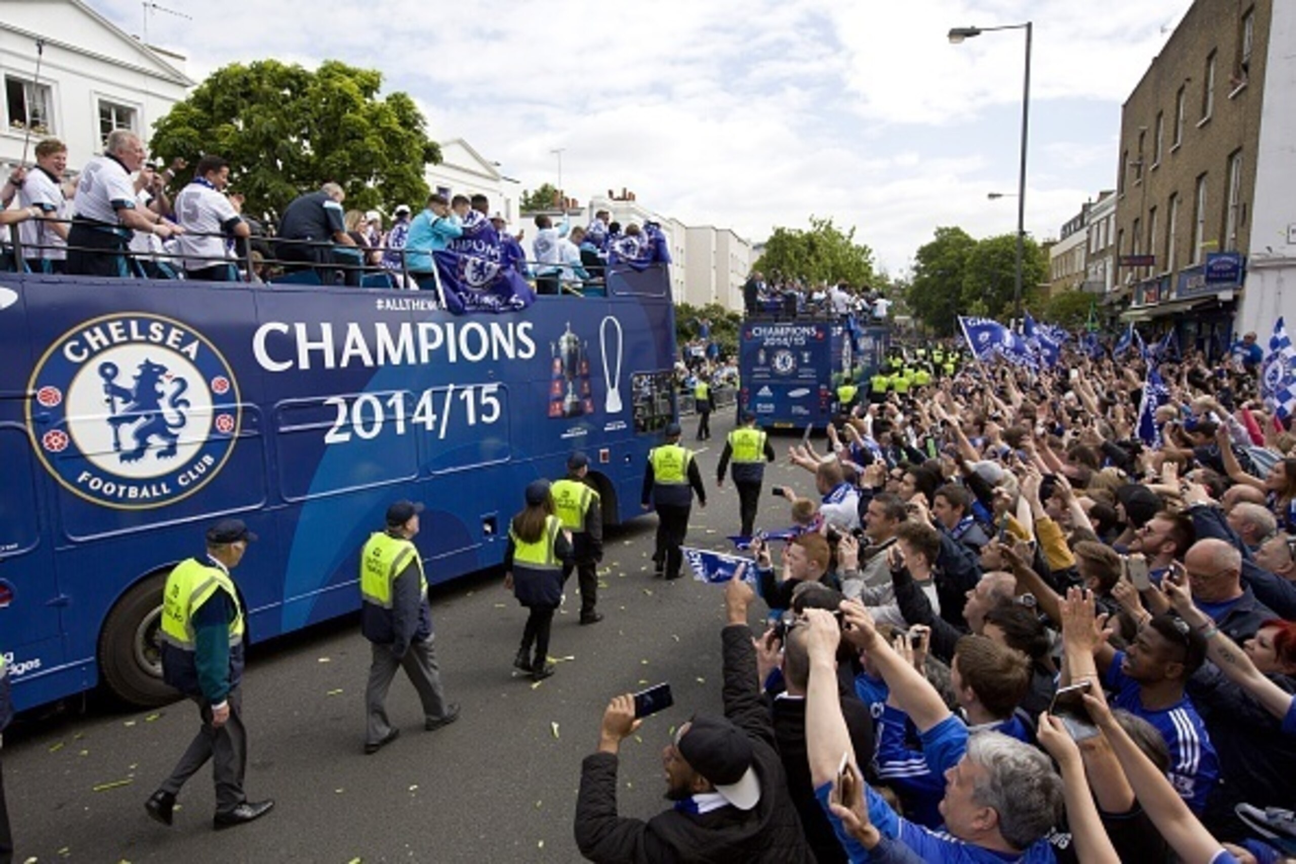 Supporters line the street as the Chelsea squad leave Stamford Bridge stadium in an open-top bus parade to celebrate winning the league in west London on May 25, 2015. 
AFP PHOTO / JUSTIN TALLIS        (Photo credit should read JUSTIN TALLIS/AFP/Getty Ima