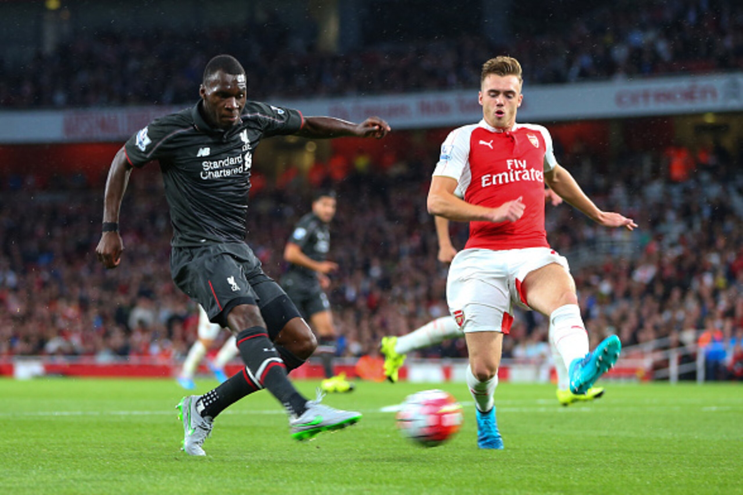 LONDON, ENGLAND - AUGUST 24:  Christian Benteke of Liverpool shoots past Calum Chambers of Arsenal during the Barclays Premier League match between Arsenal and Liverpool at the Emirates Stadium on August 24, 2015 in London, United Kingdom.  (Photo by Cath