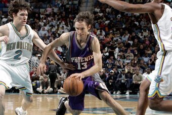 NEW ORLEANS - DECEMBER 29:  Steve Nash #13 of the Phoenix Suns drives between Dan Dickau #2 and Lee Nailon #33 of the New Orleans Hornets at the New Orleans Arena on December 29, 2004 in New Orleans, Louisiana.  NOTE TO USER: User expressly acknowledges a
