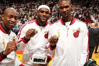 MIAMI, FL - OCTOBER 29: Dwyane Wade #3, LeBron James #6 and Chris Bosh #1 of the Miami Heat holds up their rings during the ceremony before the game against the Chicago Bulls on October 29, 2013 at American Airlines Arena in Miami, Florida. NOTE TO USER: 