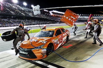 DAYTONA BEACH, FL - FEBRUARY 19:  Carl Edwards, driver of the #19 Arris Toyota, slides through his pit box and a crew member jumps over the hood during the NASCAR Sprint Cup Series Budweiser Duel 2 at Daytona International Speedway on February 19, 2015 in