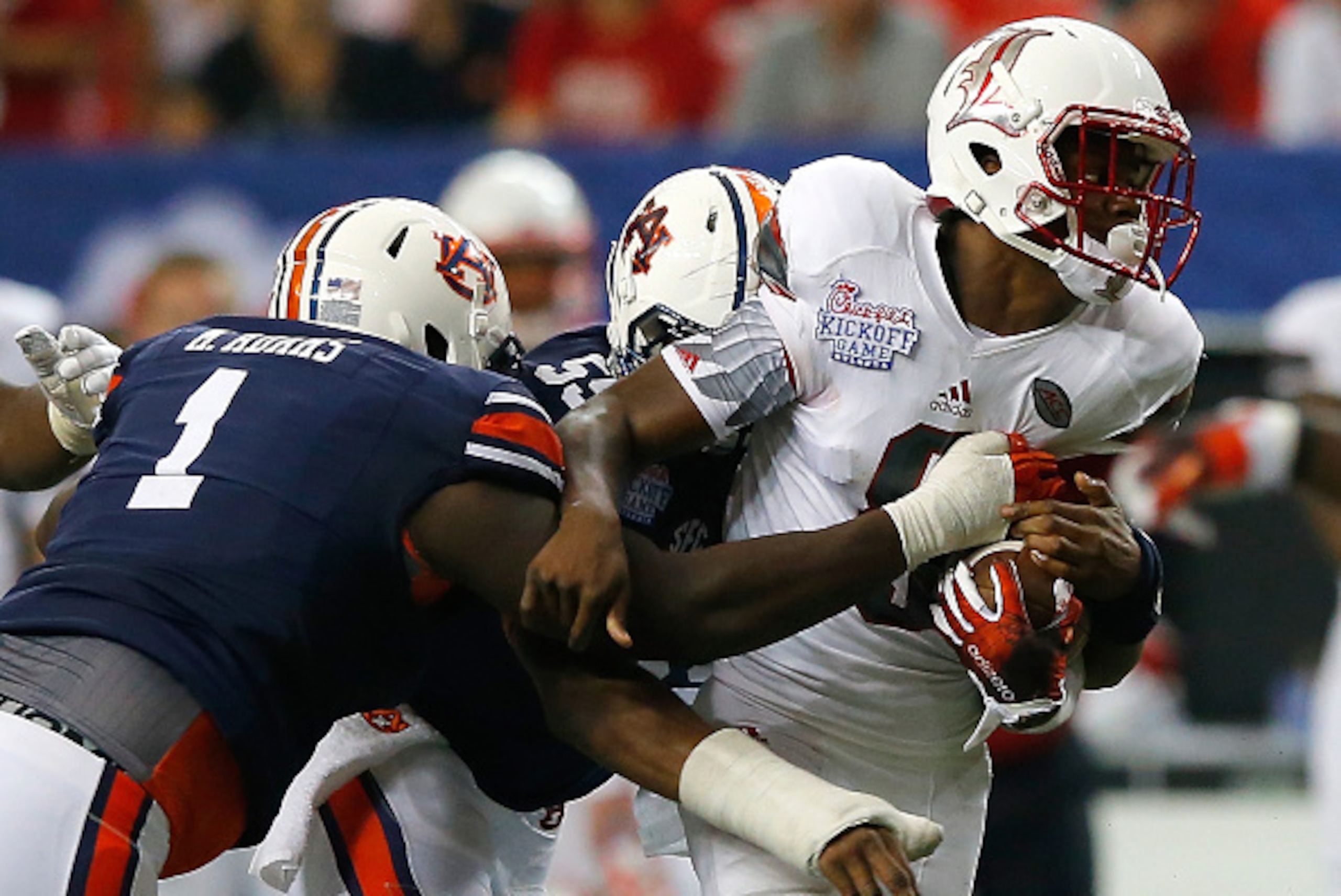 ATLANTA, GA - SEPTEMBER 05:  Lamar Jackson #8 of the Louisville Cardinals is tackled by Montravius Adams #1 and Devonte Danzey #53 of the Auburn Tigers at Georgia Dome on September 5, 2015 in Atlanta, Georgia.  (Photo by Kevin C. Cox/Getty Images)