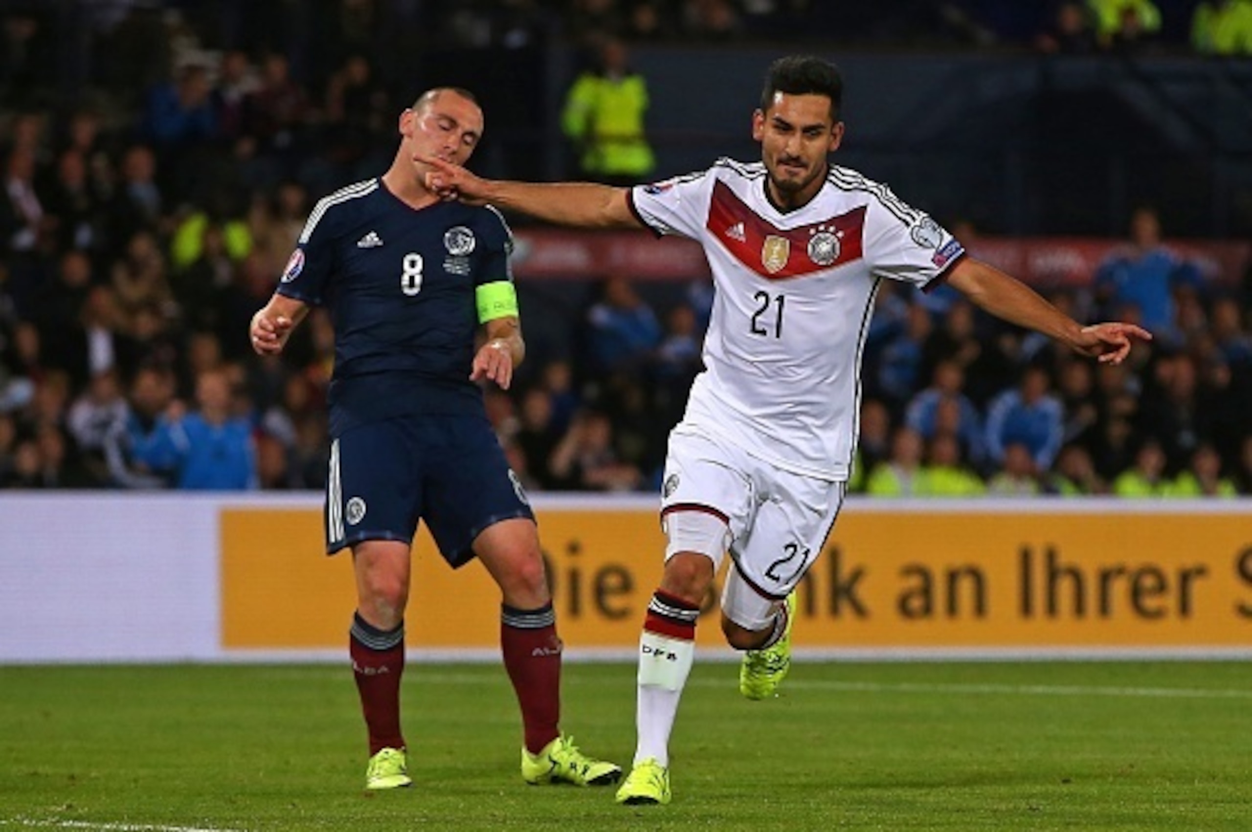 Germany's midfielder Ilkay Gundogan (R) celebrates after scoring their third goal as Scotland's midfielder Scott Brown reacts behind during the Euro 2016 qualifying group D football match between Scotland and Germany at Hampden Park in Glasgow on Septembe