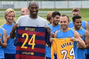 Los Angeles Lakers basketball star Kobe Bryant (C L) and Barcelona team captain Andrés Iniesta Luján (C R) pose with other members of the FC Barcelona football team before a training session at the StarHub Stadium in Carson, California, on July 20, 2015. 