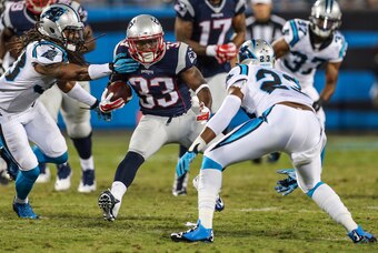Aug 28, 2015; Charlotte, NC, USA; New England Patriots running back Dion Lewis (33) tries to elude Carolina Panthers cornerback Melvin White (23) during the second half at Bank of America Stadium. New England wins 17-16 over the Panthers. Mandatory Credit