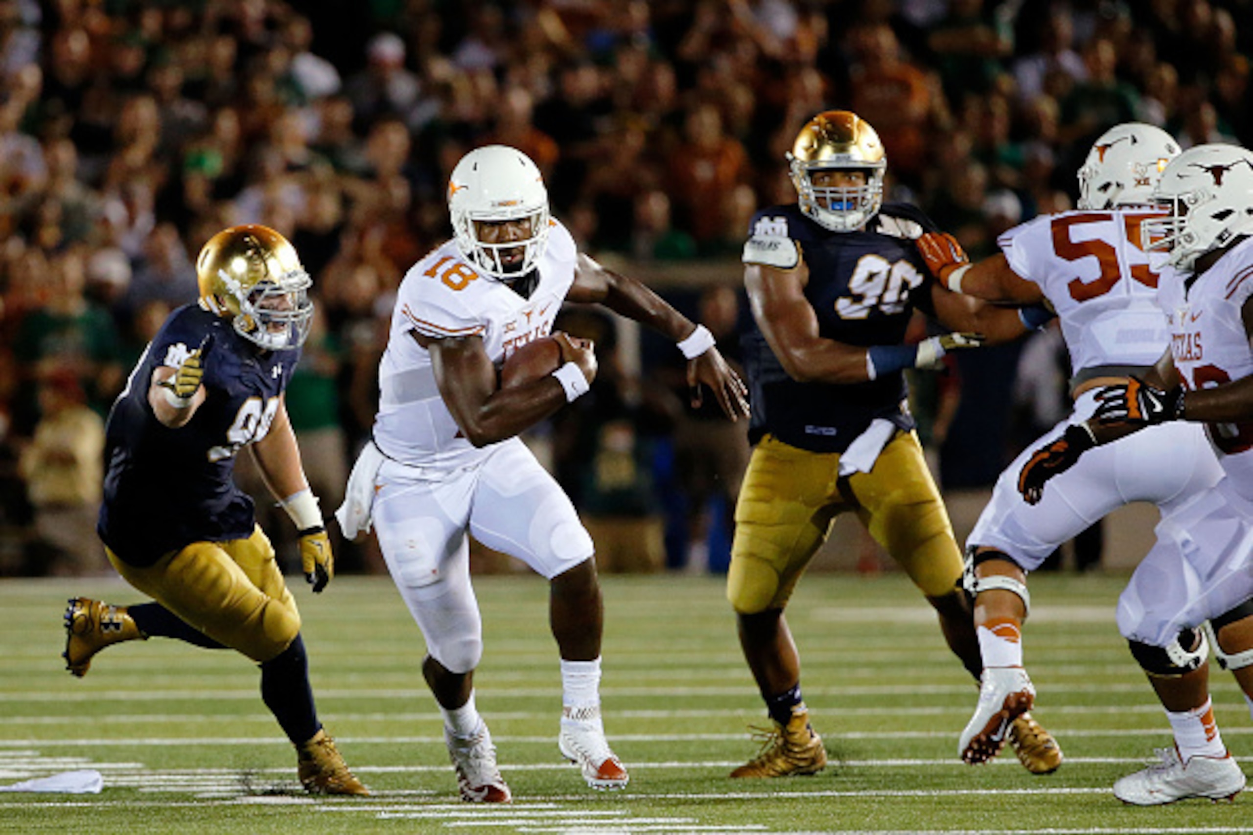 SOUTH BEND, IN - SEPTEMBER 05: Tyrone Swoopes #18 of the Texas Longhorns avoids the tackle of Jerry Tillery #99 of the Notre Dame Fighting Irish (L) during the second quarter at Notre Dame Stadium on September 5, 2015 in South Bend, Indiana.  (Photo by Jo