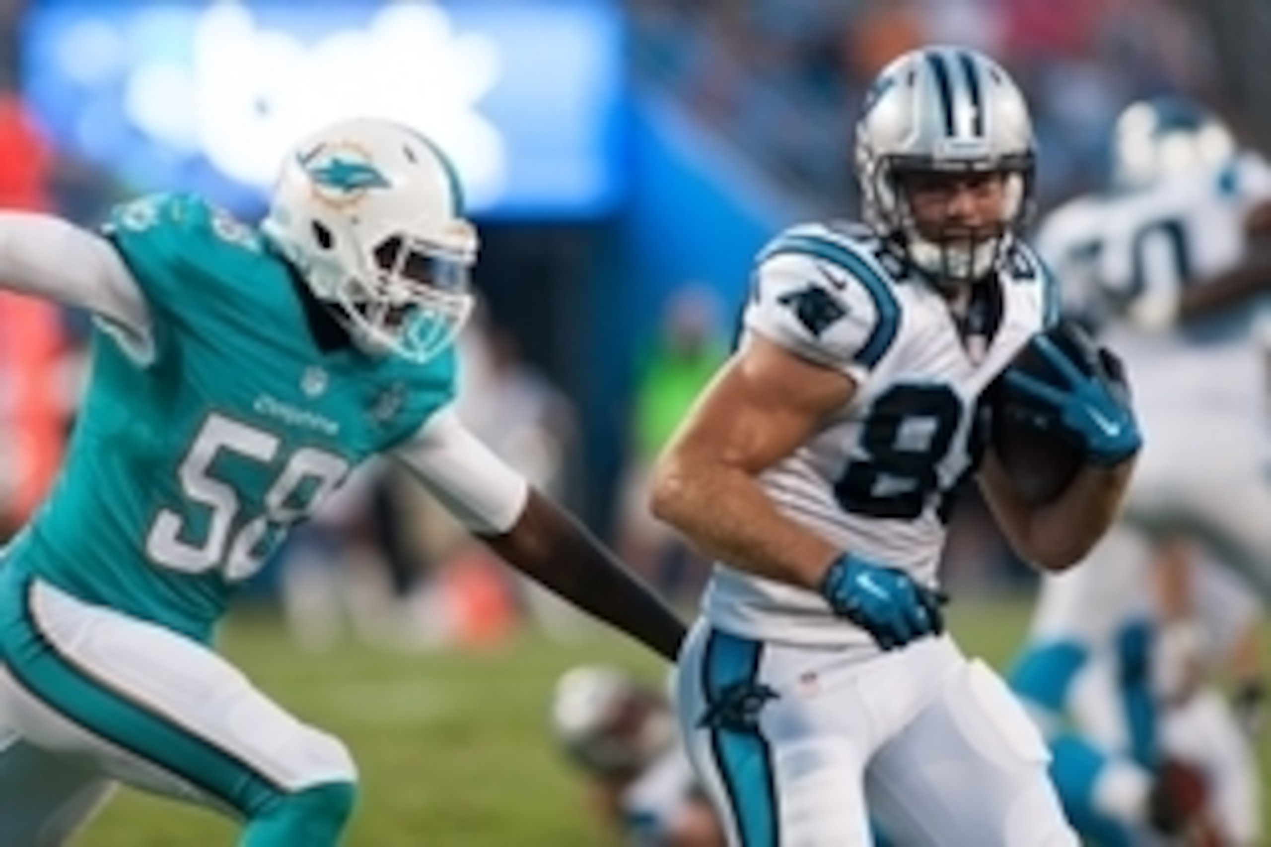 Aug 22, 2015; Charlotte, NC, USA; Carolina Panthers tight end Greg Olsen (88) runs after making a catching a pass while Miami Dolphins linebacker Chris McCain (58) pursues during the second quarter at Bank of America Stadium. Mandatory Credit: Jeremy Brev