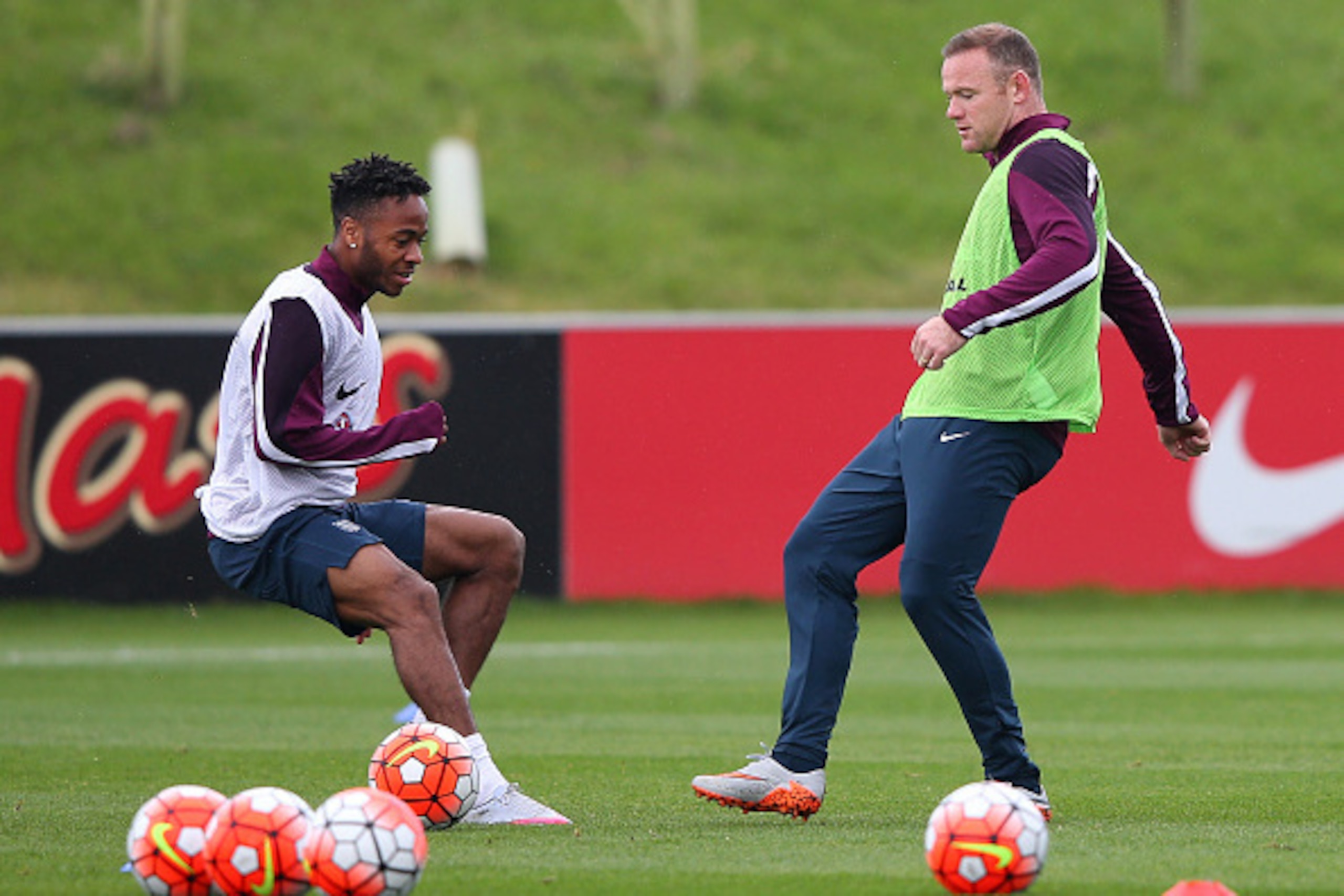 BURTON-UPON-TRENT, ENGLAND - SEPTEMBER 02:  Wayne Rooney of England passes the ball past Raheem Sterling during a England training session at St Georges Park on September 2, 2015 in Burton-upon-Trent, England.  (Photo by Alex Livesey/Getty Images)