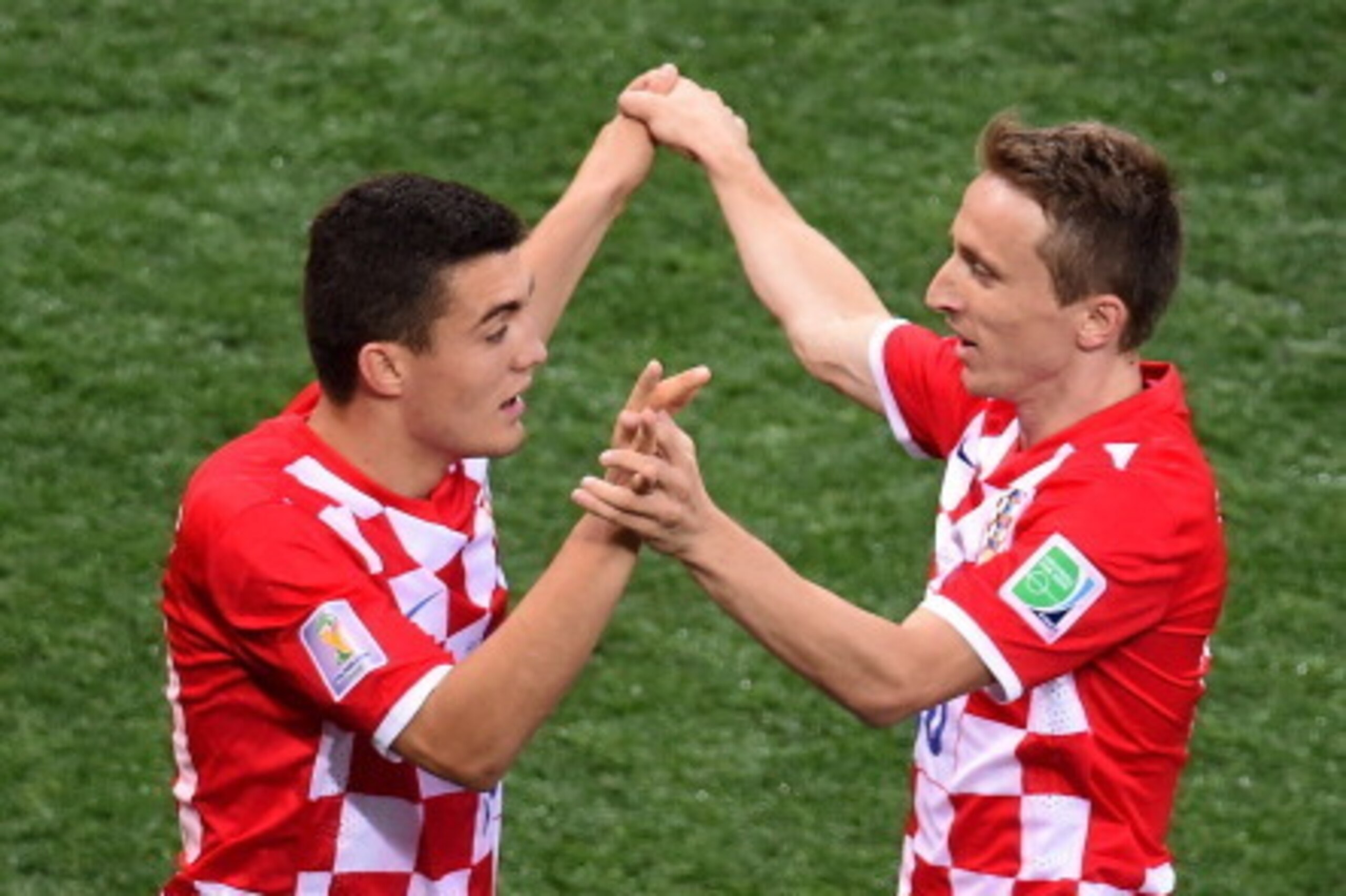 Croatia's midfielder Luka Modric (R) and teammate midfielder Mateo Kovacic celebrate after unseen Brazil defender Marcelo scored an own goal during a Group A football match between Brazil and Croatia at the Corinthians Arena in Sao Paulo on June 12, 2014,