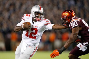 BLACKSBURG, VA - SEPTEMBER 7: Cardale Jones #12 of the Ohio State Buckeyes tries to run the ball past Dadi L'homme Nicolas #90 of the Virginia Tech Hokies in the first quarter at Lane Stadium on September 7, 2015 in Blacksburg, Virginia. (Photo by Joe Rob