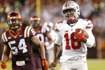 Sep 7, 2015; Blacksburg, VA, USA; Ohio State Buckeyes quarterback J.T. Barrett (16) runs with the ball as Virginia Tech Hokies linebacker Andrew Motuapuaka (54) chases in the fourth quarter at Lane Stadium. The Buckeyes won 42-24. Mandatory Credit: Geoff 