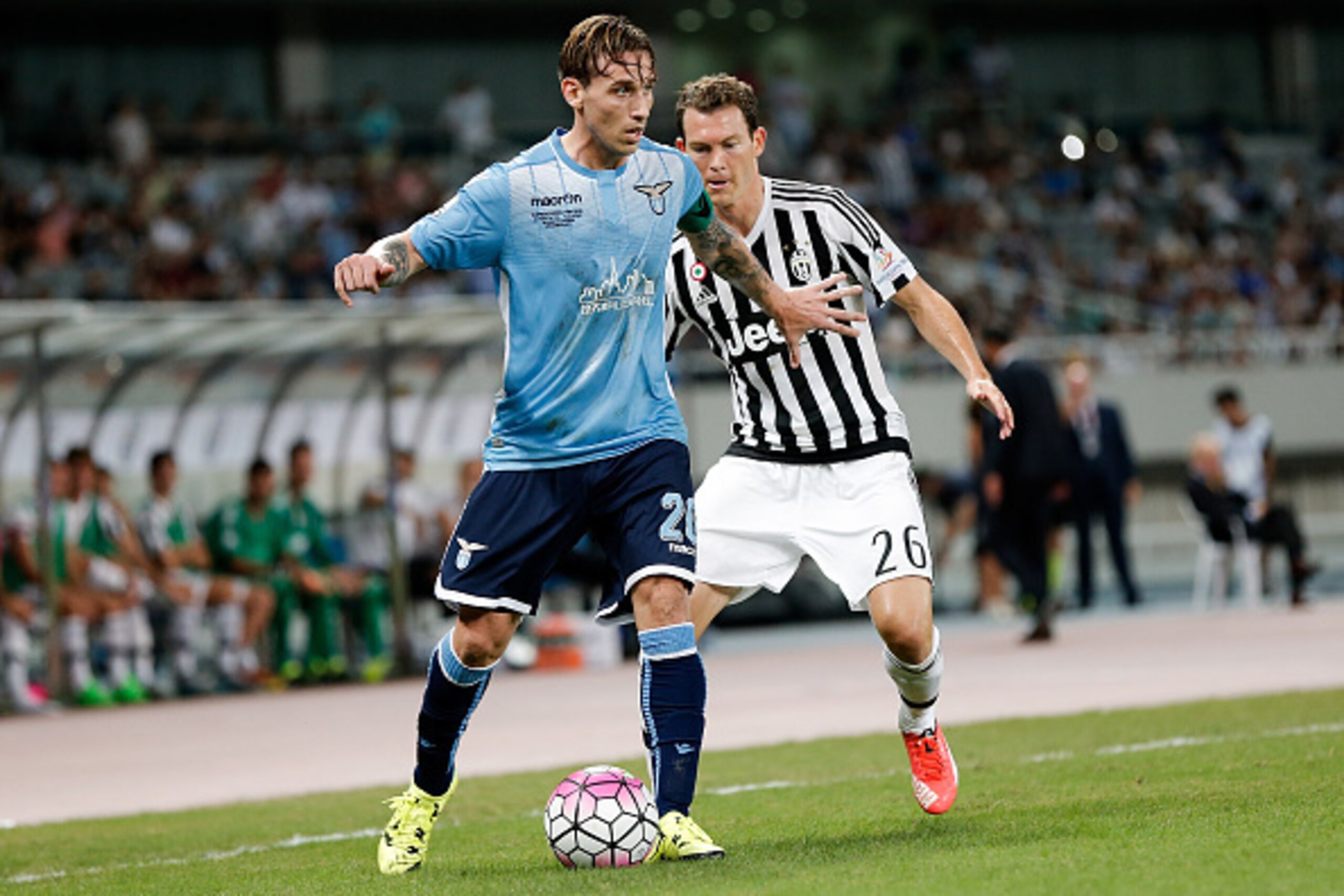 SHANGHAI, CHINA - AUGUST 08:  Stephan Lichtsteiner (L) of Juventus FC contests the ball against Lucas Biglia (R) of Lazio during the Italian Super Cup final football match between Juventus and Lazio at Shanghai Stadium on August 8, 2015 in Shanghai, China