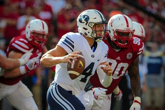 LINCOLN, NE - SEPTEMBER 5: Quarterback Taysom Hill #4 of the Brigham Young Cougars runs past defensive end Greg McMullen #90 of the Nebraska Cornhuskers during their game at Memorial Stadium on September 5, 2015 in Lincoln, Nebraska. (Photo by Eric Franci