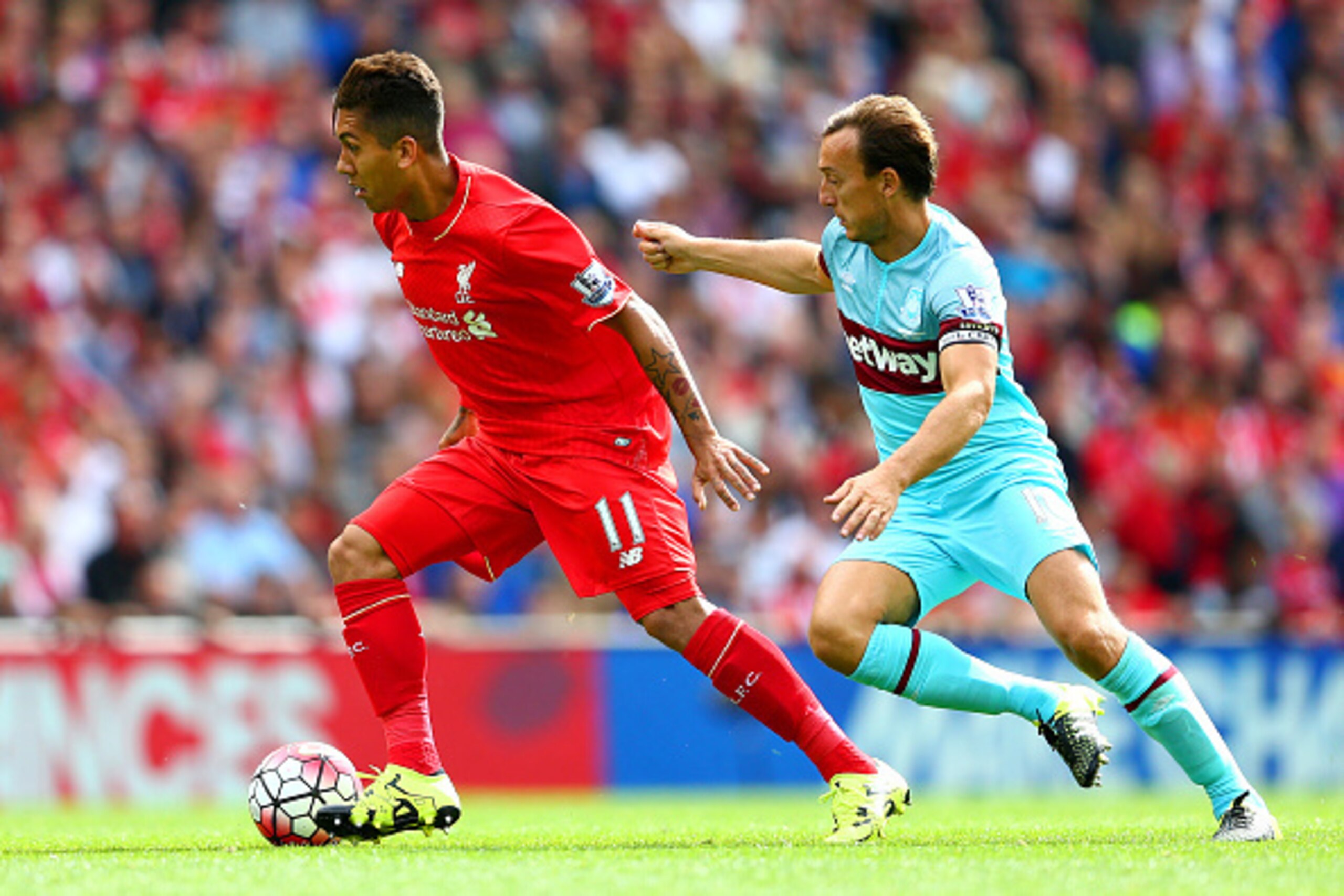LIVERPOOL, ENGLAND - AUGUST 29:  Roberto Firmino of Liverpool and Mark Noble of West Ham United compete for the ball during the Barclays Premier League match between Liverpool and West Ham United at Anfield on August 29, 2015 in Liverpool, England.  (Phot