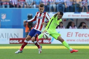 Atletico Madrid's French midfielder Antoine Griezmann (L) vies with Barcelona's French defender Dani Alves during the Spanish league football match Club Atletico de Madrid vs FC Barcelona at the Vicente Calderon stadium in Madrid on May 17, 2015.   AFP PH