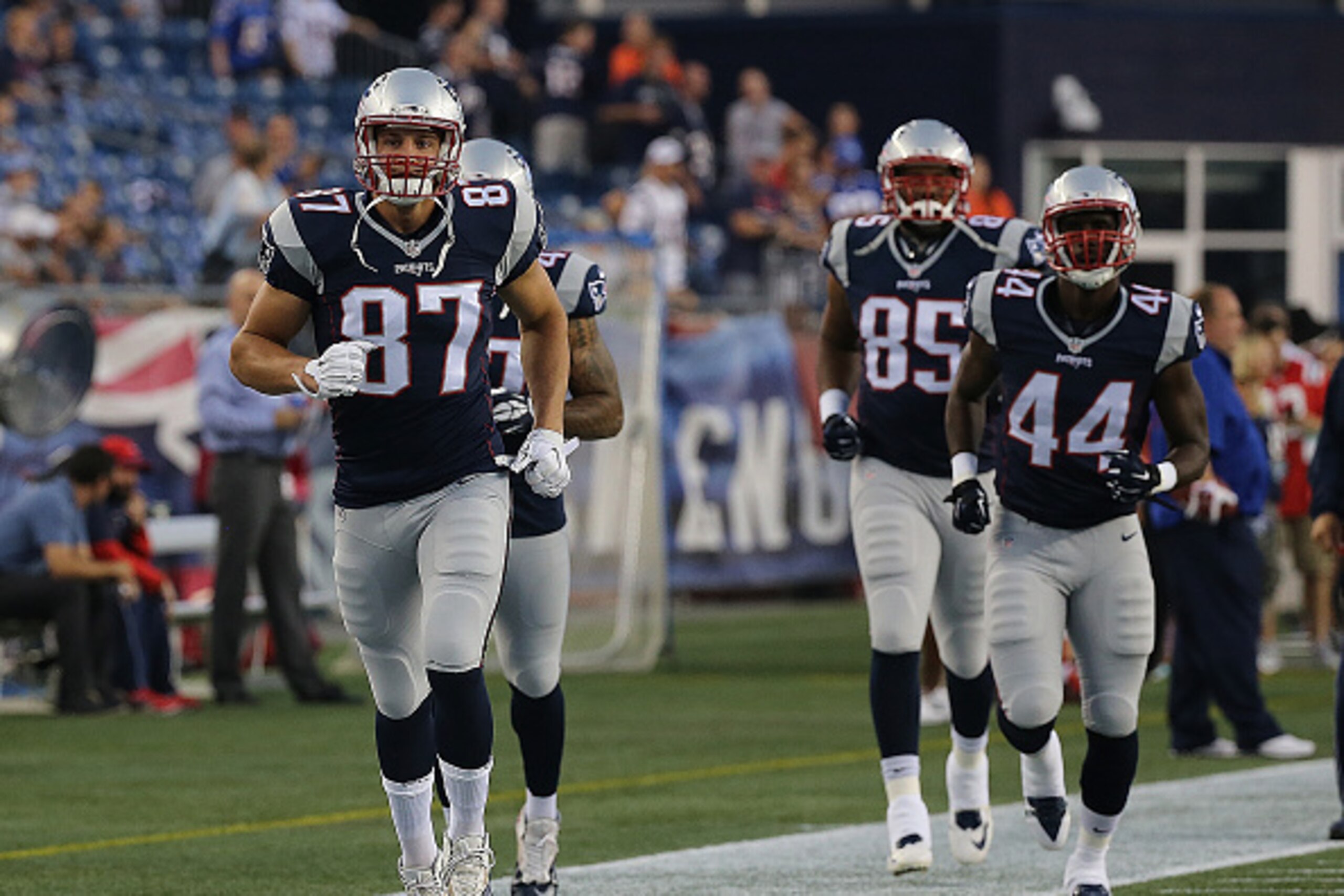 FOXBORO, MA - SEPTEMBER 3:   Rob Gronkowski #87 of the New England Patriots leads Asante Cleveland #44 and Jake Bequette #85 onto the field before a pre-season game with the New York Giants at Gillette Stadium on September 3, 2015 in Foxboro, Massachusett
