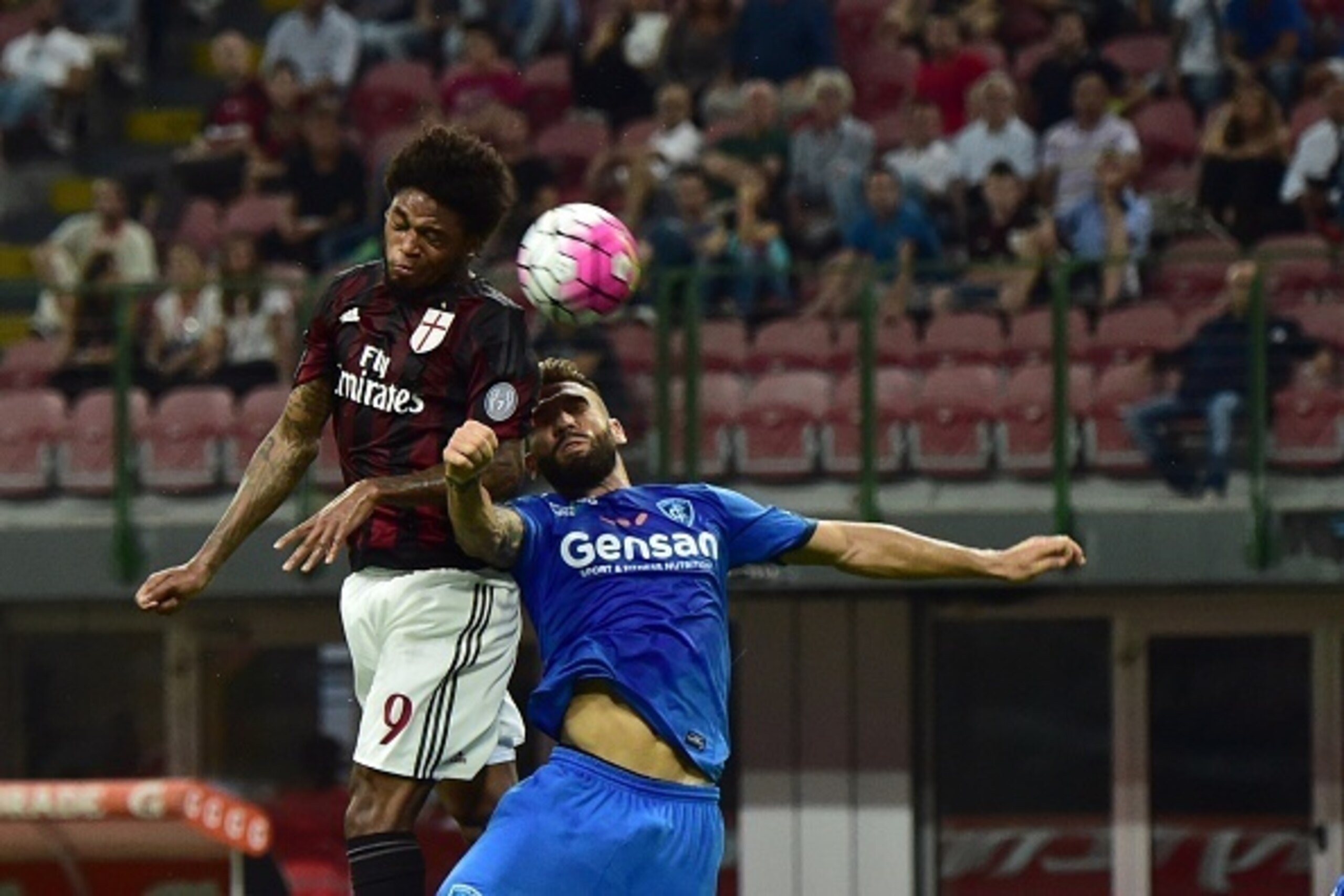 AC Milan's forward from Brazil Luiz Adriano (L) jumps for the ball during the Italian Serie A football match between AC Milan and Empoli  at San Siro Stadium in Milan on August 29, 2015. AFP PHOTO / GIUSEPPE CACACE        (Photo credit should read GIUSEPP