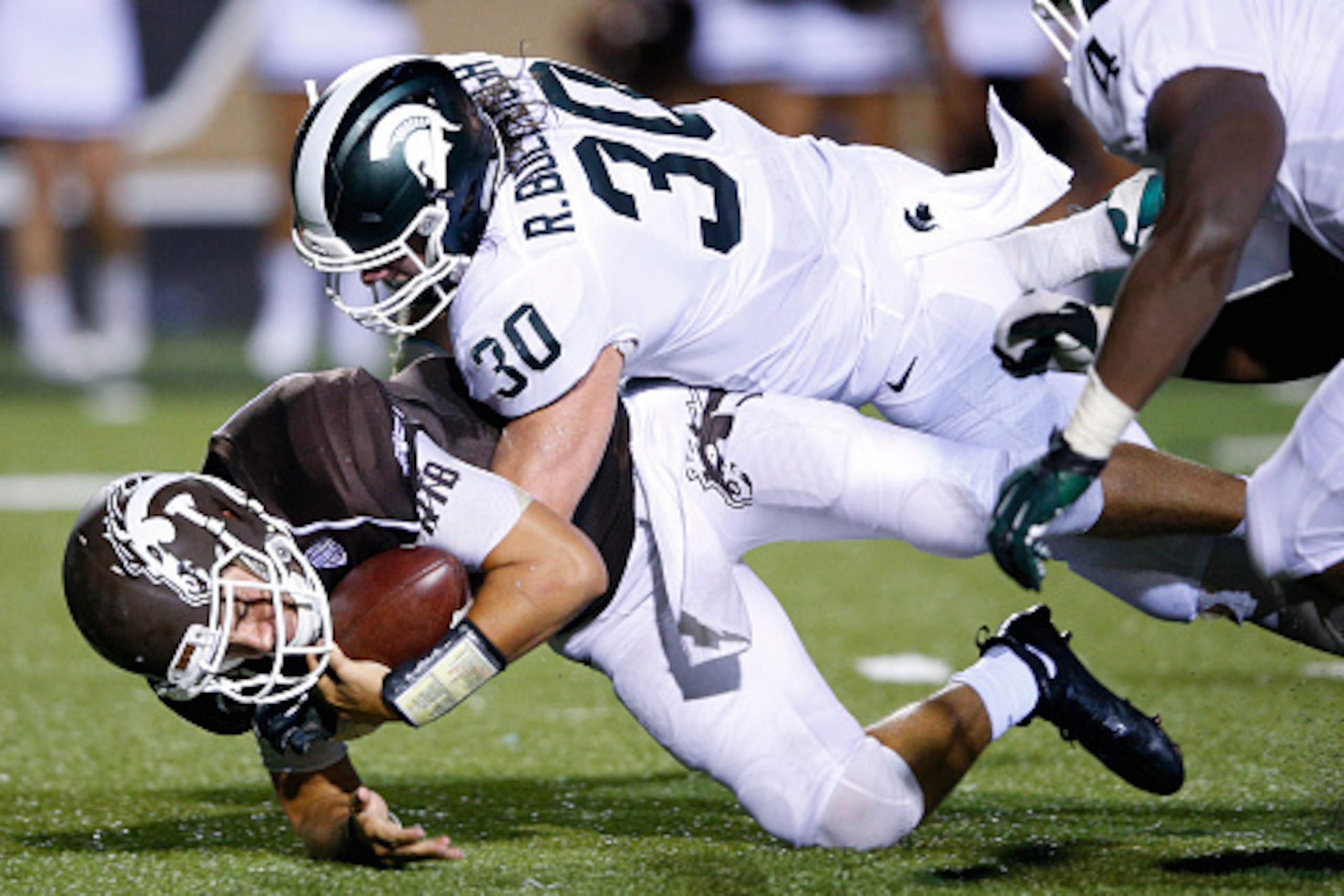 KALAMAZOO, MI - SEPTEMBER 4: Zach Terrell #11 of the Western Michigan Broncos is sacked by Riley Bullough #30 of the Michigan State Spartans in the second half at Waldo Stadium on September 4, 2015 in Kalamazoo, Michigan. The Spartans defeated the Broncos