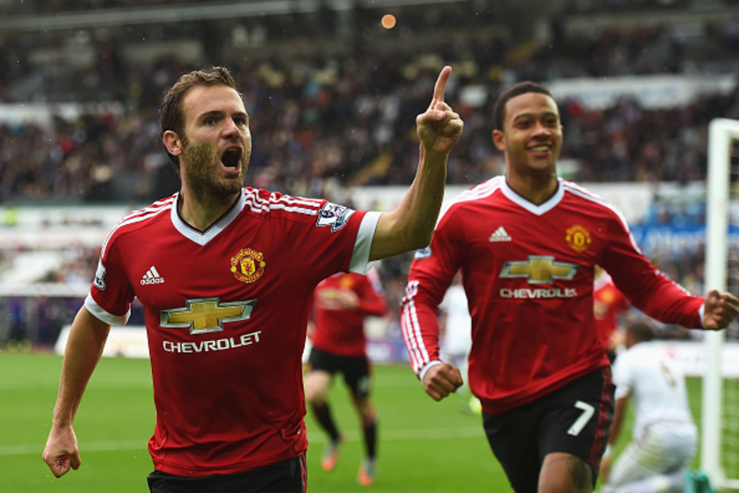 SWANSEA, WALES - AUGUST 30:  Juan Mata (L) of Manchester United celebrates scoring the opening goal with Memphis Depay during the Barclays Premier League match between Swansea City and Manchester United at Liberty Stadium on August 30, 2015 in Swansea, Wa