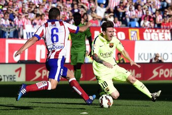 Barcelona's Argentinian forward Lionel Messi (R) vies with Atletico Madrid's midfielder Koke during the Spanish league football match Club Atletico de Madrid vs FC Barcelona at the Vicente Calderon stadium in Madrid on May 17, 2015.   AFP PHOTO / GERARD J