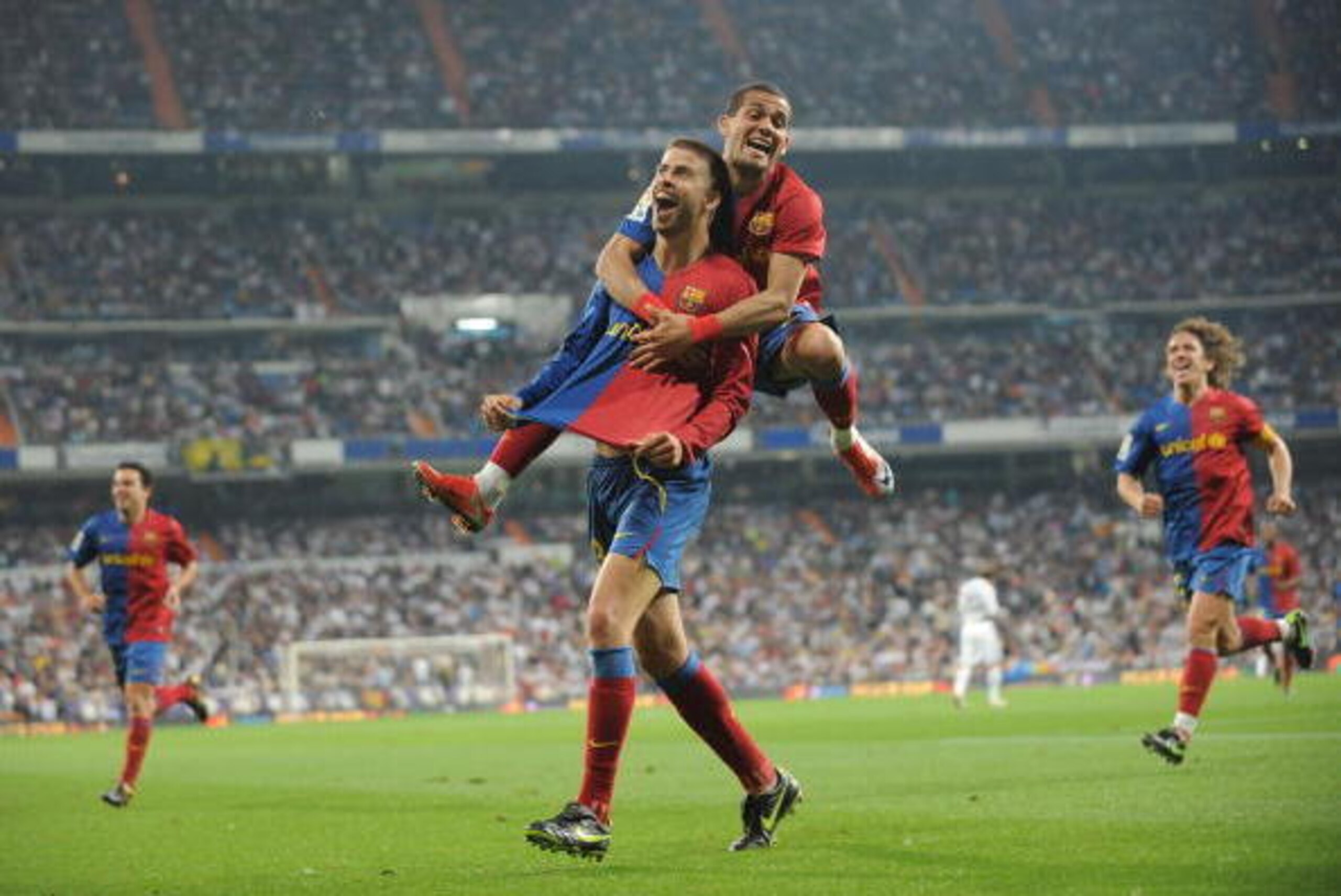 MADRID, SPAIN - MAY 02:  Gerard Pique (L) of Barcelona celebrates with Dani Alves after scoring Barcelona's sixth goal during the La Liga match between Real Madrid and Barcelona at the Santiago Bernabeu stadium on May 2, 2009 in Madrid, Spain.  (Photo by 