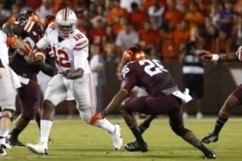 Sep 7, 2015; Blacksburg, VA, USA; Ohio State Buckeyes quarterback Cardale Jones (12) runs with the ball Virginia Tech Hokies safety Desmond Frye (26) attempts the tackle in the first quarter at Lane Stadium. Mandatory Credit: Geoff Burke-USA TODAY Sports