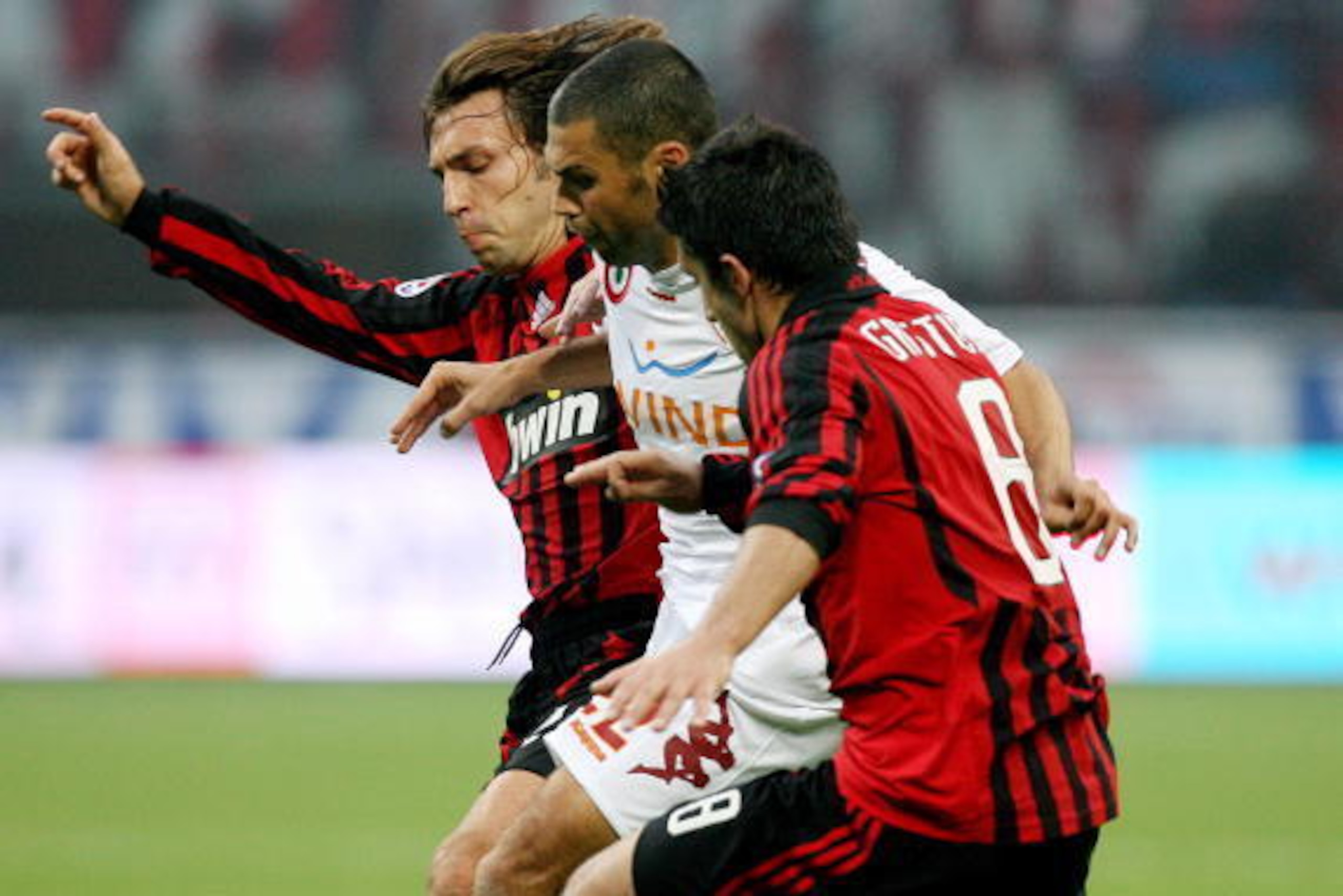 AS Roma's midfielder Max Tonetto (C) challenges for the ball with A.C. Milan's midfielder Andrea Pirlo (back) and A.C. Milan's midfielder Gennaro Ivan Gattuso (R) during their Italian serie A football match at San Siro stadium in Milan 28 October 2007. AF