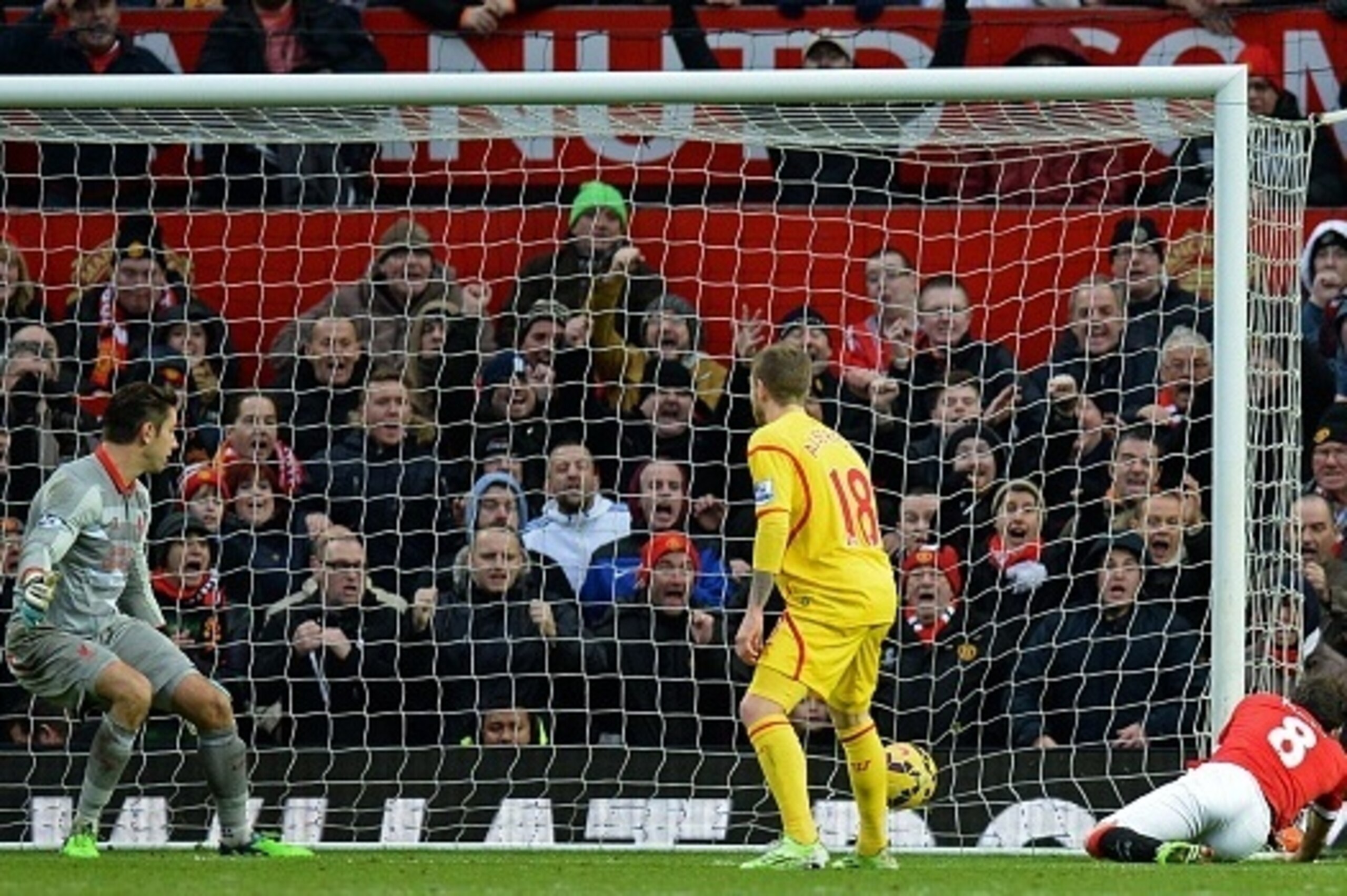 Manchester United's Spanish midfielder Juan Mata (R) scores their second goal as Liverpool's Australian goalkeeper Brad Jones (L) looks on during the English Premier League football match between Manchester United and Liverpool at Old Trafford in Manchest