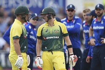 Australia's captain Steven Smith (R) talks to Australia's Aaron Finch (L) about whether to review a decision before leaving the field out lbw off the bowling of England's David Willey for five runs during the fourth one day international (ODI) cricket mat
