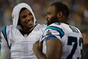 CHARLOTTE, NC - AUGUST 28:  Cam Newton #1 talks with teammate Michael Oher #73 of the Carolina Panthers during their preseason NFL game against the New England Patriots at Bank of America Stadium on August 28, 2015 in Charlotte, North Carolina.  (Photo by