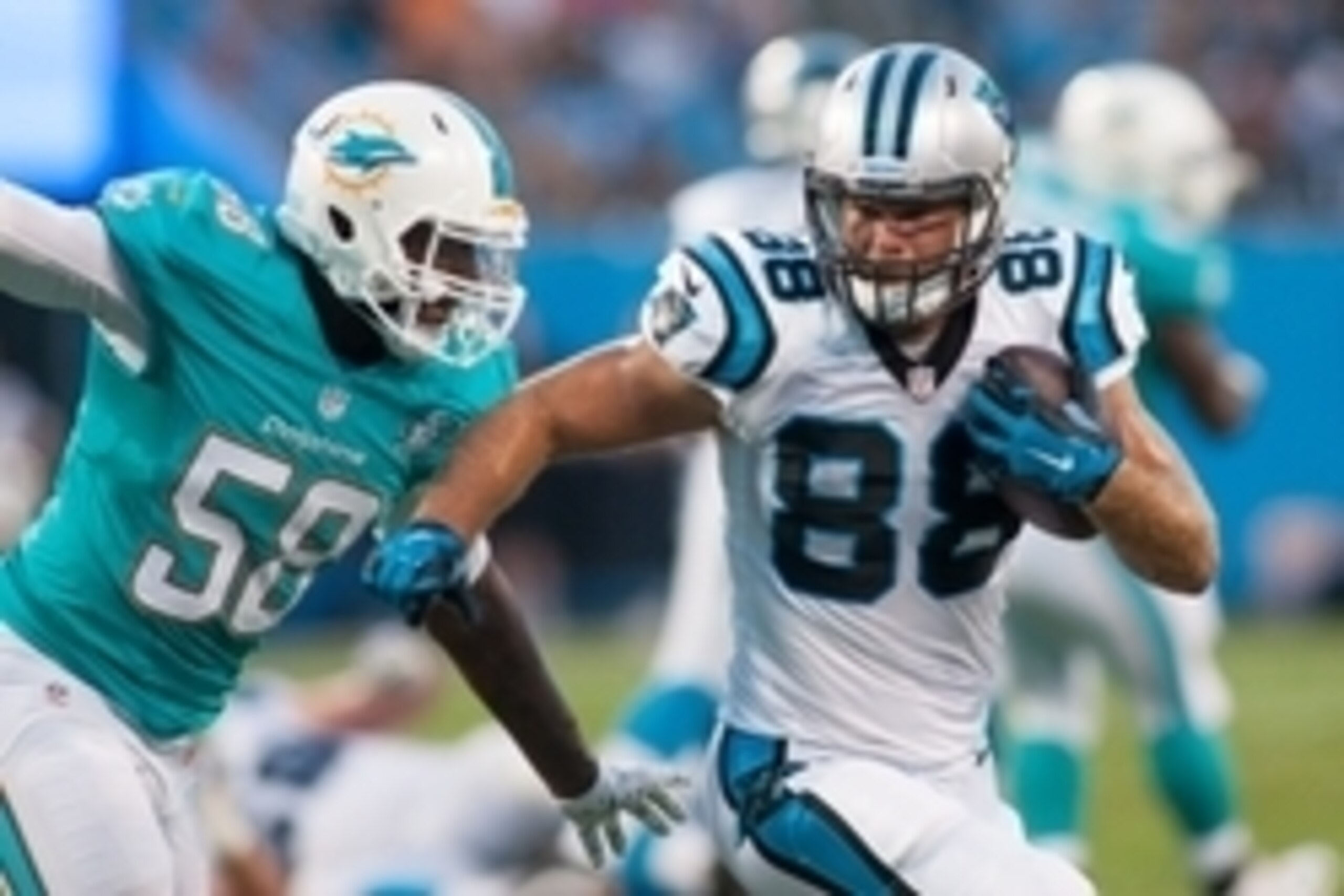 Aug 22, 2015; Charlotte, NC, USA; Carolina Panthers tight end Greg Olsen (88) runs after making a catching a pass while Miami Dolphins linebacker Chris McCain (58) pursues during the second quarter at Bank of America Stadium. Mandatory Credit: Jeremy Brev