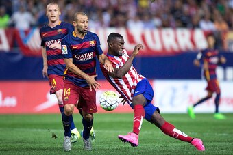 MADRID, SPAIN - SEPTEMBER 12: Jackson Arley Martinez  (R) of Atletico de Madrid strikes the ball ahead Javier Alejandro Mascherano (L) of FC Barcelona during the La Liga match between Club Atletico de Madrid and FC Barcelona at Vicente Calderon Stadium on