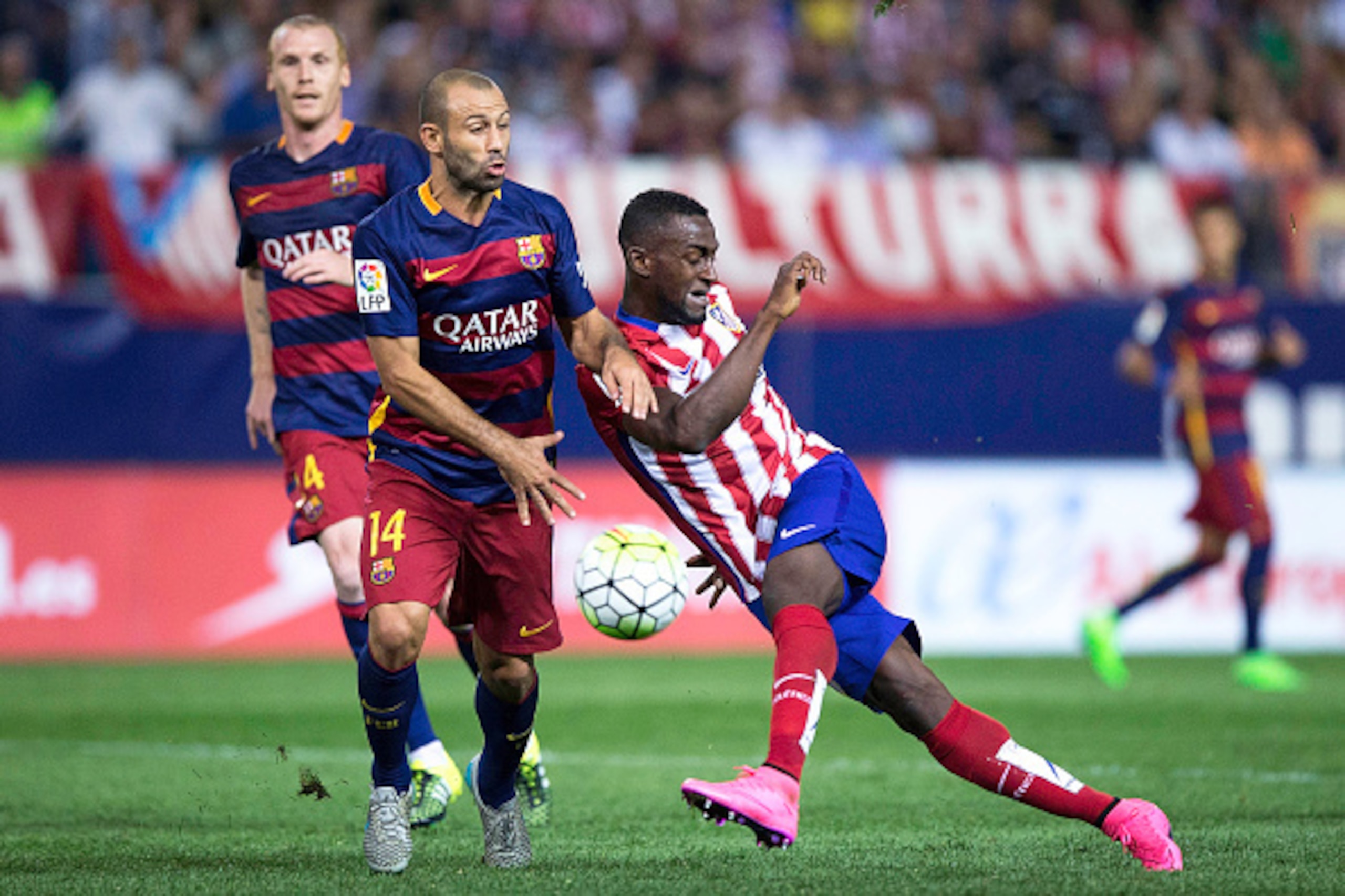 MADRID, SPAIN - SEPTEMBER 12: Jackson Arley Martinez  (R) of Atletico de Madrid strikes the ball ahead Javier Alejandro Mascherano (L) of FC Barcelona during the La Liga match between Club Atletico de Madrid and FC Barcelona at Vicente Calderon Stadium on